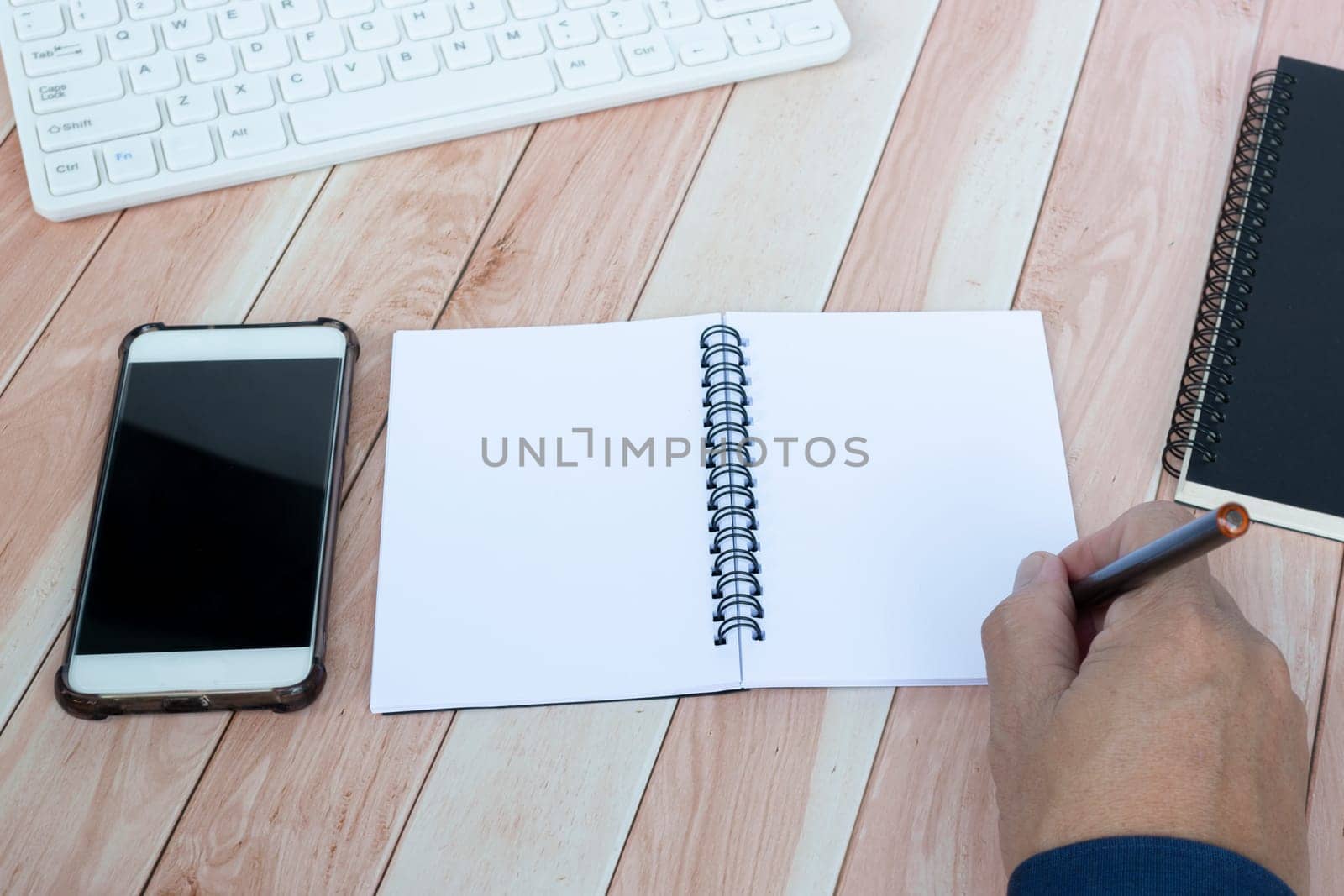 Businessman hands with pen writing notebook on office desk table. Copy space. Business concept.