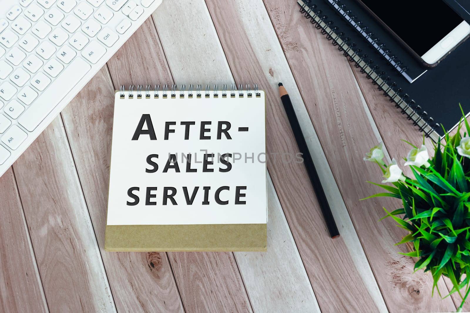 After-sales service written on notepad on wooden desk. Business concept.