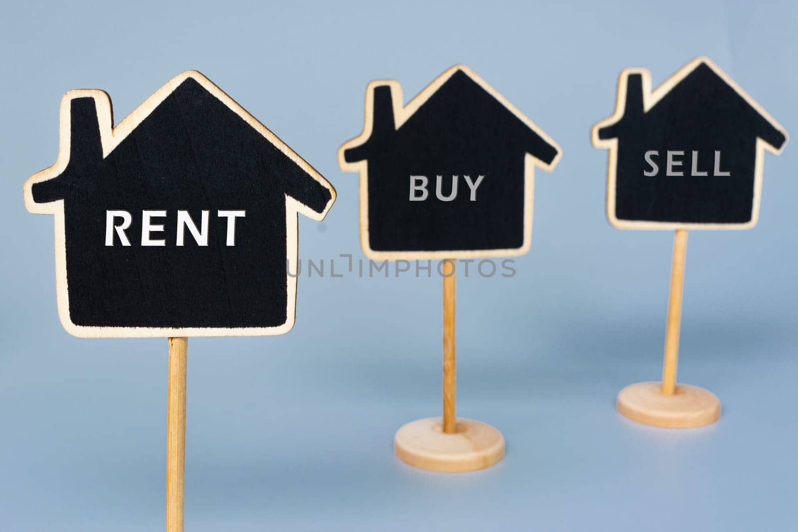 Rent buy sell text on wooden house. Property investment and business concept.