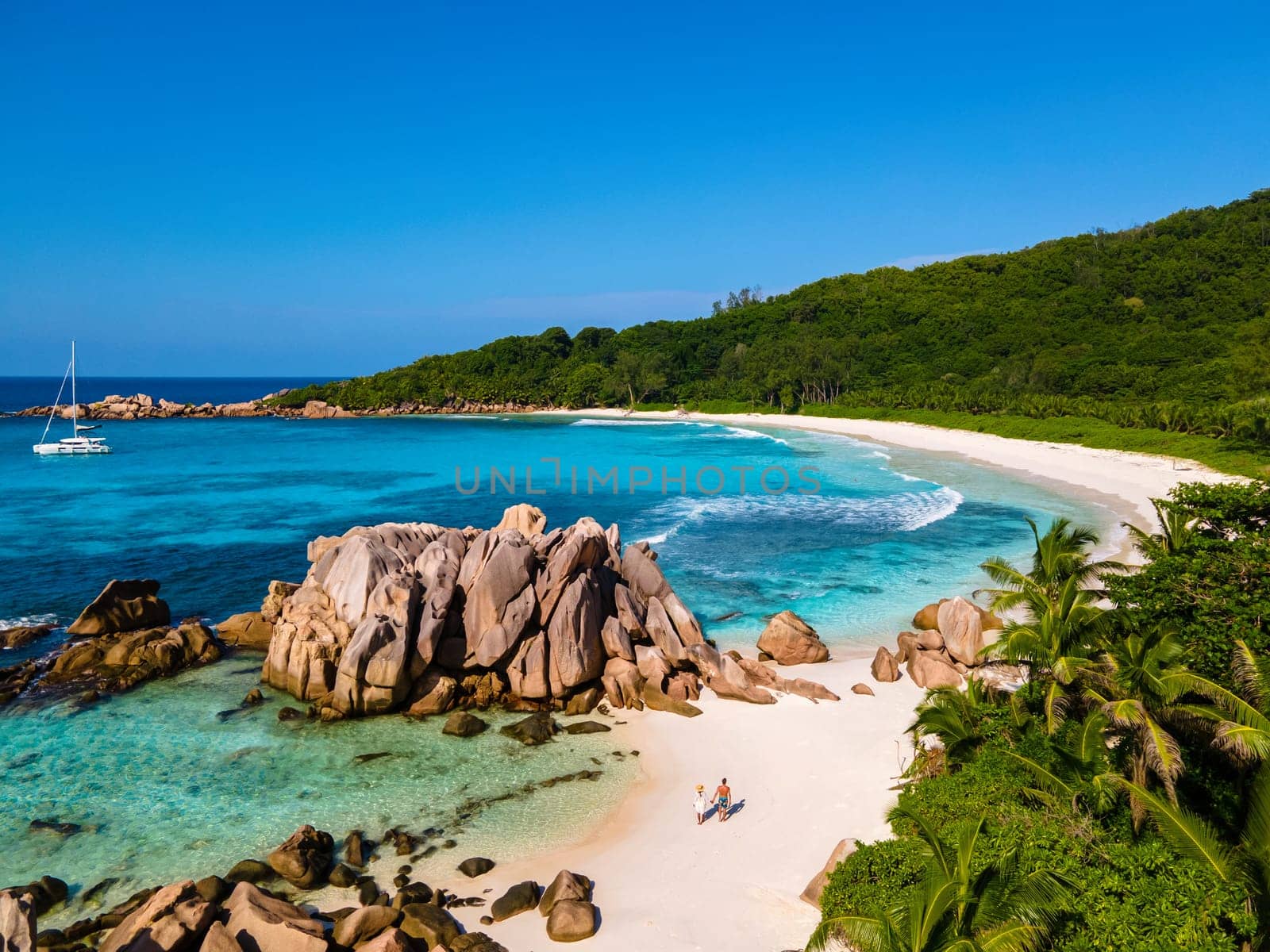 Anse Cocos beach, La Digue Island, Seychelles, Drone aerial view of La Digue Seychelles bird eye view of a tropical Island, couple men and woman walking at the beach during sunset at a luxury vacation