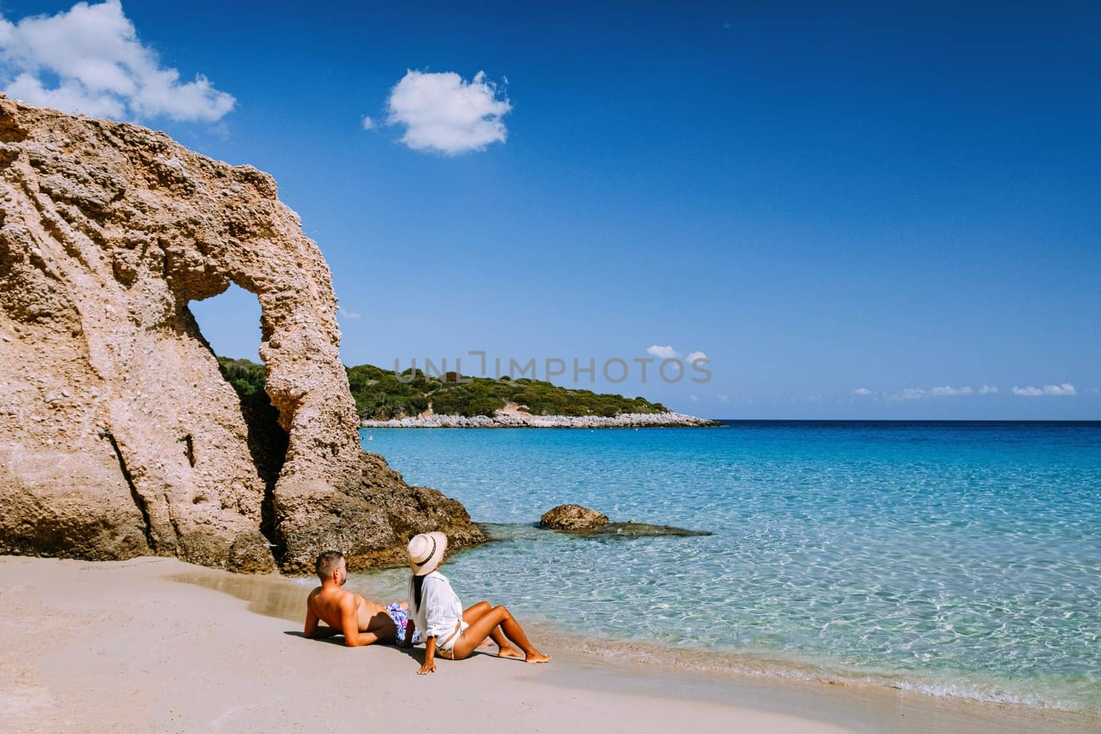 Tropical beach of Voulisma beach, Istron, Crete, Greece,Most beautiful beaches of Crete island -Istron bay near Agios Nikolaos young couple mid age on vacation in Greece Crete