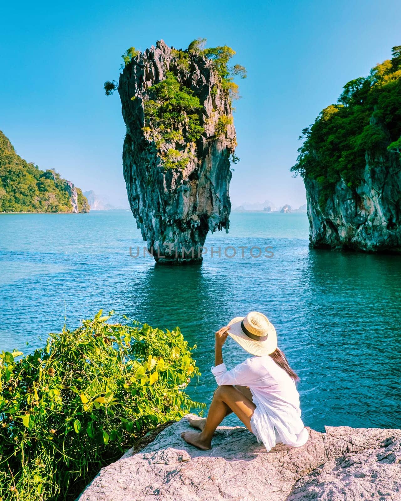 woman on vacation in Thailand visit Phangnga Bay Thailand James Bond Island, Asian woman with hat on a trip to James Bond Island in Phannga bay on a sunny day