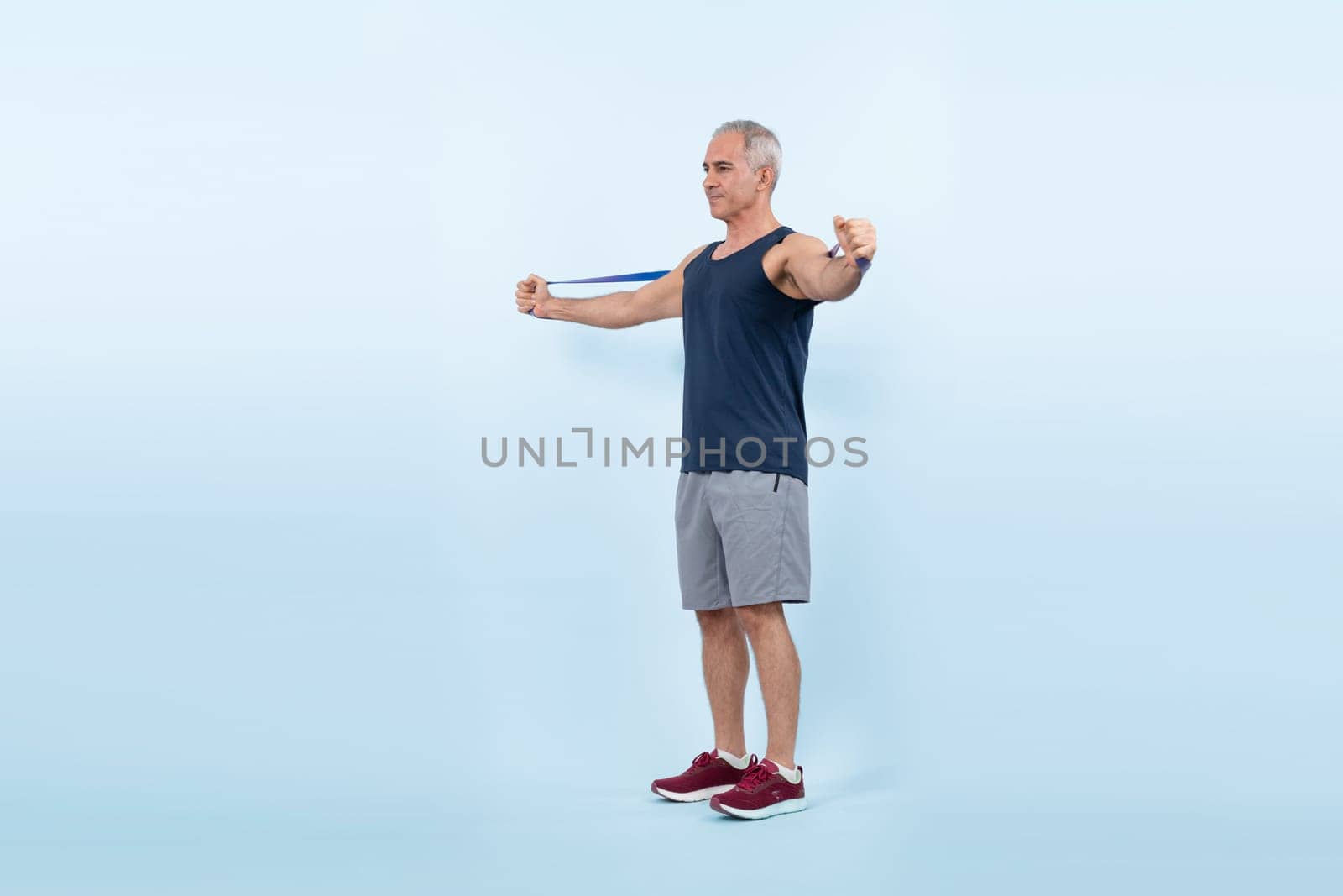 Full body length shot athletic and sporty senior man with resistance band. Clout by biancoblue