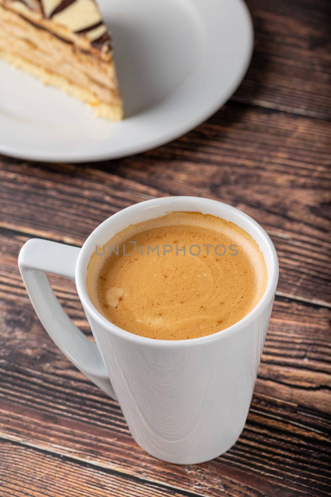 Relaxing americano coffee in white porcelain cup on wooden table