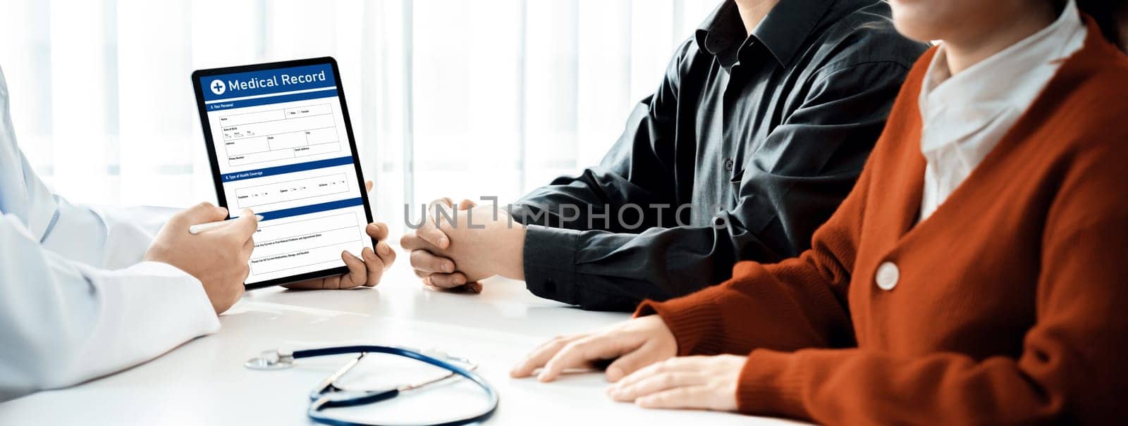 Couple attend fertility consultation with gynecologist at hospital as part family planning care for pregnancy. Loving husband and wife support each other through the doctor appointment. Panorama Rigid