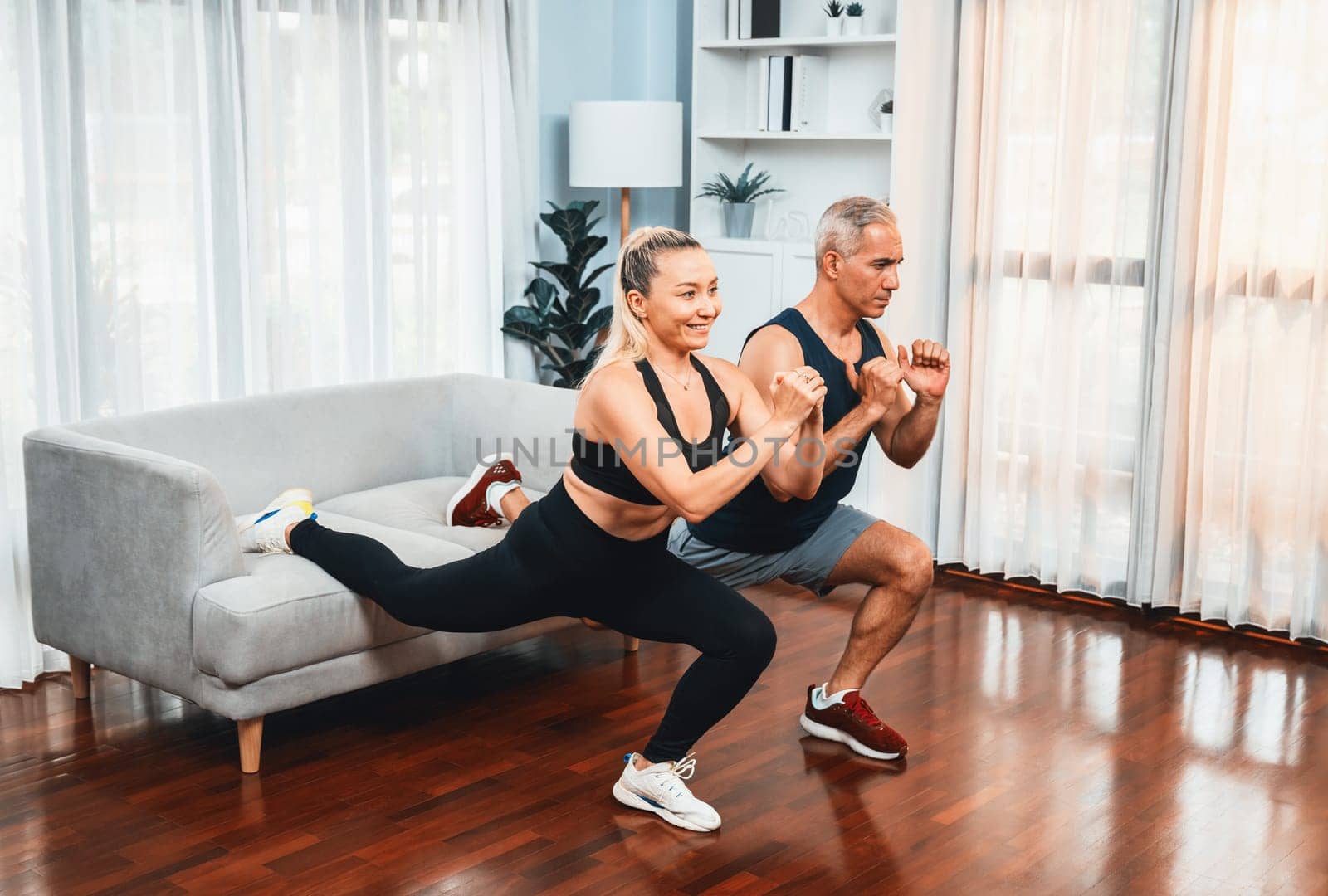 Active and fit senior couple warmup and stretching before home exercising. Clout by biancoblue