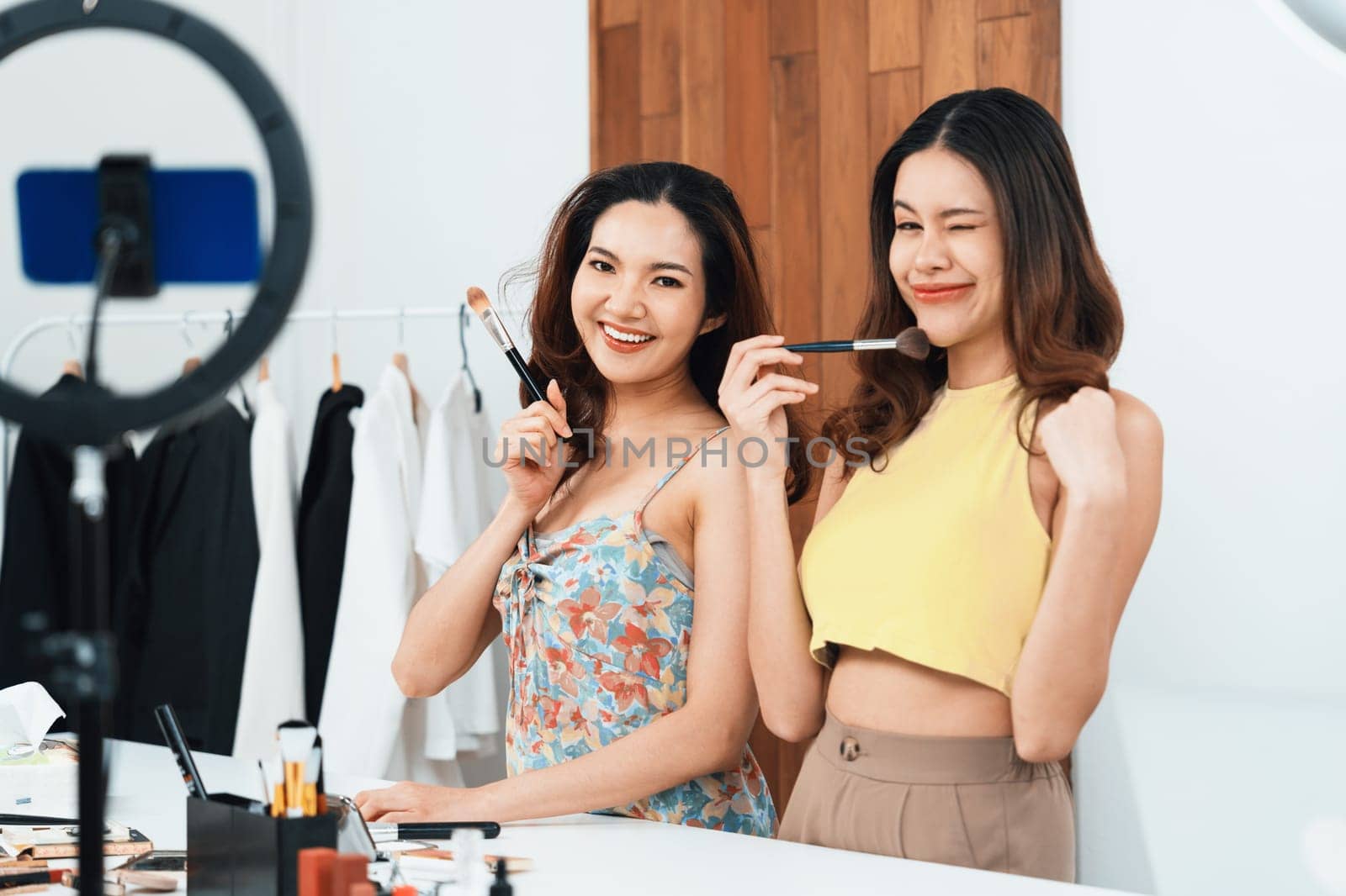 Woman influencer shoot live streaming vlog video review makeup uttermost social media or blog. Happy young girl with cosmetics studio lighting for marketing recording session broadcasting online.