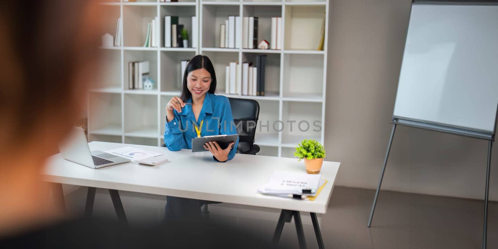 Young business woman looking at clipboard, analyzing project statistics, marketing research results or statistics data, developing marketing strategy, working at office by nateemee