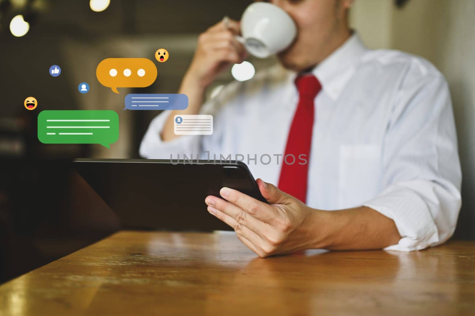Young businessman drinking hot coffee using digital tablet with icons social media.