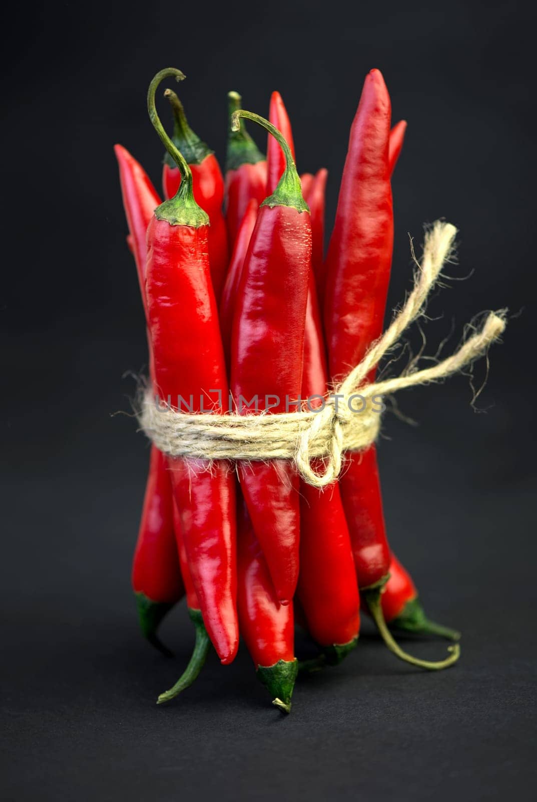 Chili pepper isolated on a black background. Knitted hot chili pepper tied with a rope. Chili hot pepper clipping path by aprilphoto