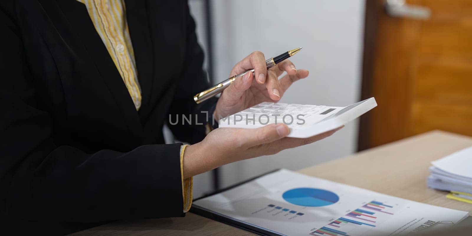 Businesswoman accountant using calculator and laptop for financial data saving in office room, Business financial, tax, accounting concept.