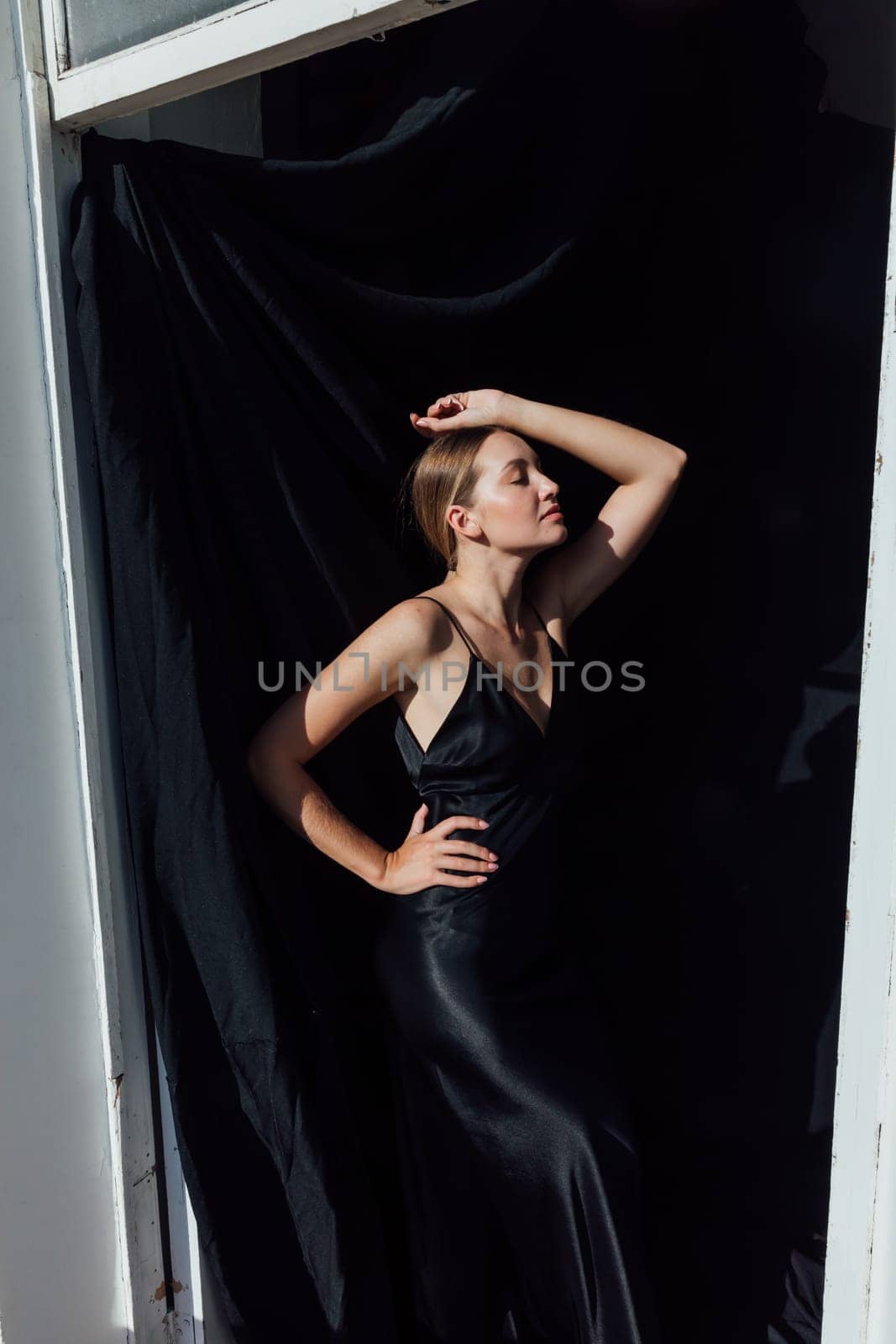 Portrait of a beautiful young woman in a black silk evening dress