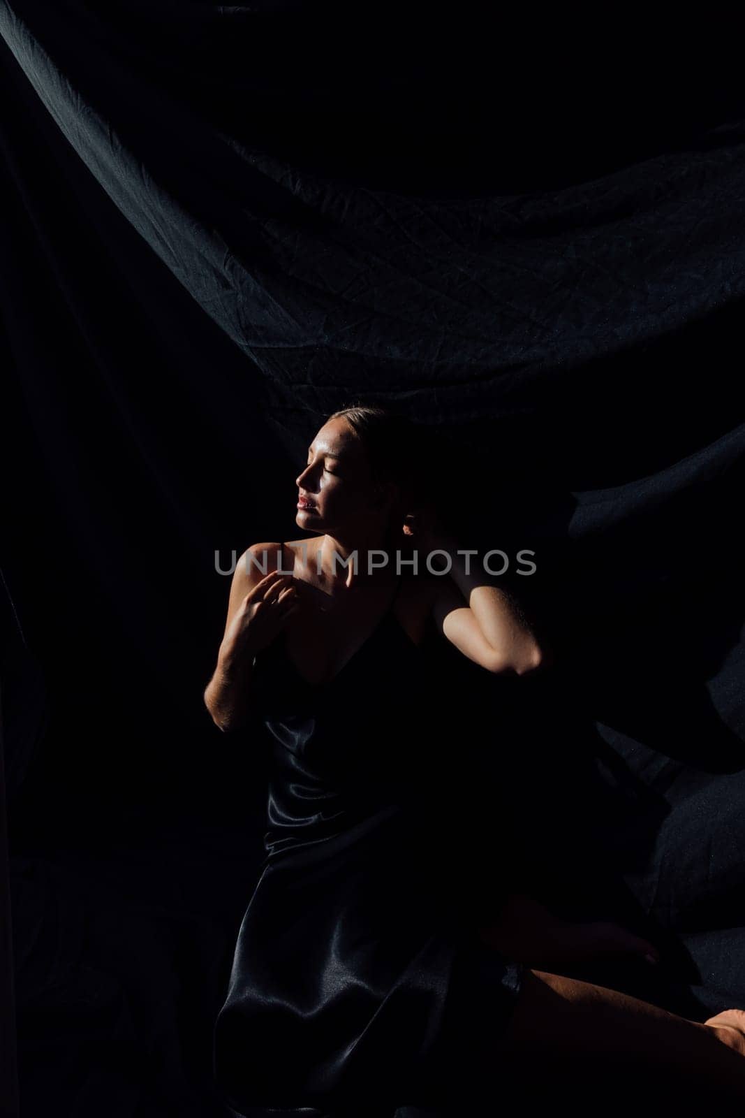 Portrait of a beautiful young woman in a black silk evening dress