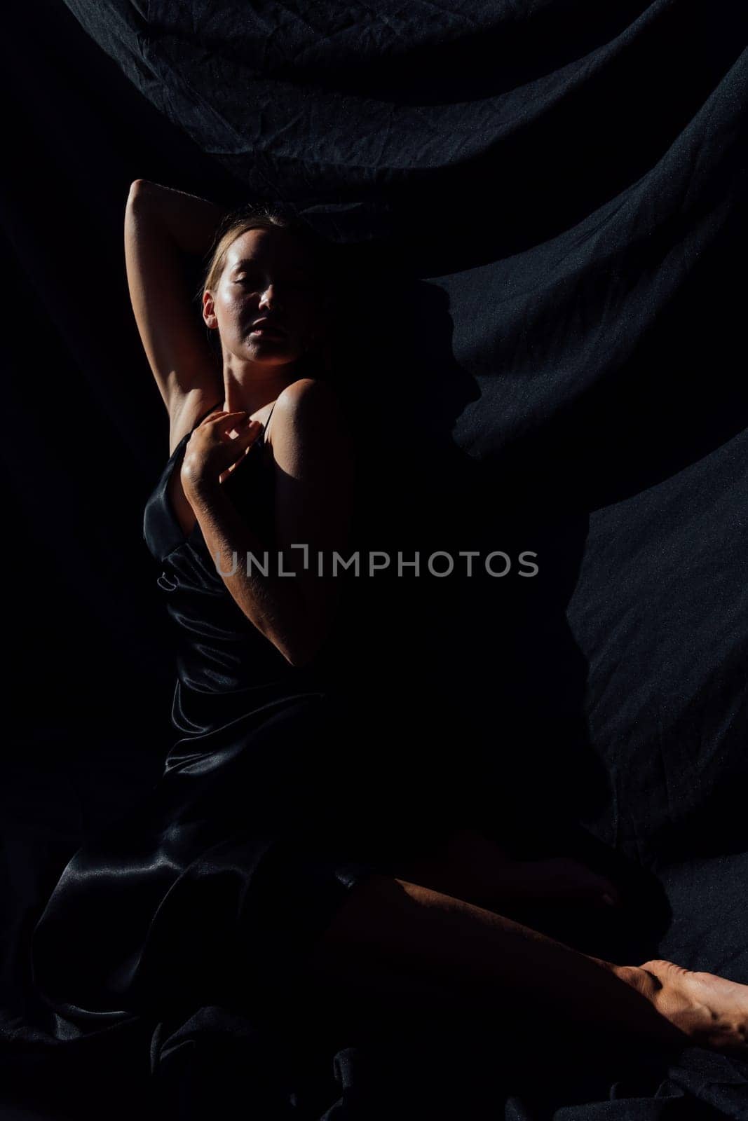 Portrait of a beautiful young woman in a black silk evening dress