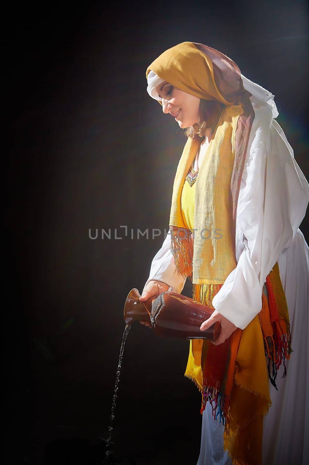 A girl or young woman from ancient Israel, Palestine, Iran, Iraq with a clay jug. A biblical story with Rebekah and water. Stylized photo shoot with a model in Middle Eastern clothes