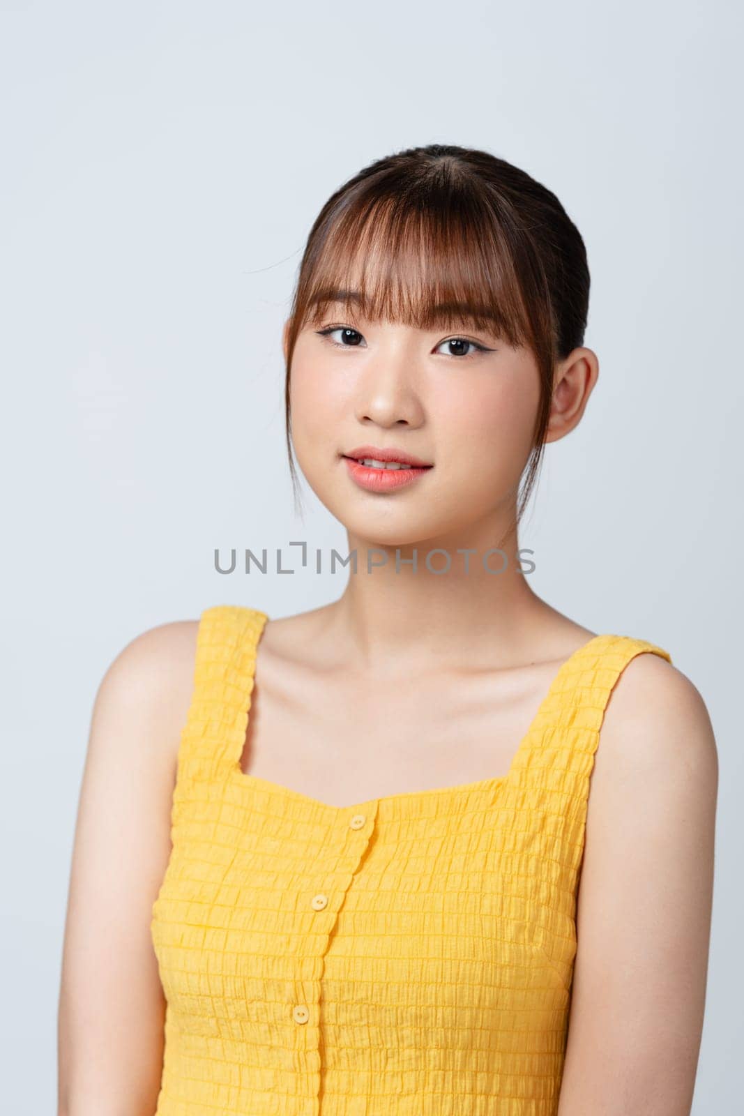 Portrait of smiling, young woman on white background