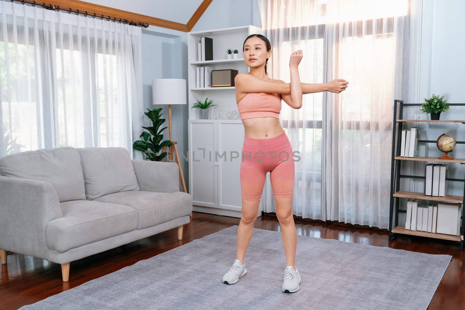 Young attractive asian woman in sportswear stretching. Vigorous by biancoblue