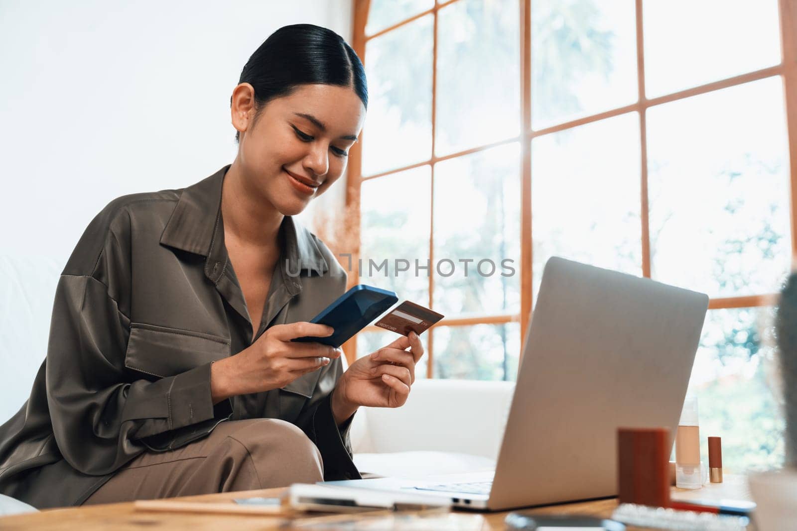 Young happy Asian woman buy product by online shopping at home while ordering items from the internet with credit card online payment protected by uttermost cyber security from online store platform