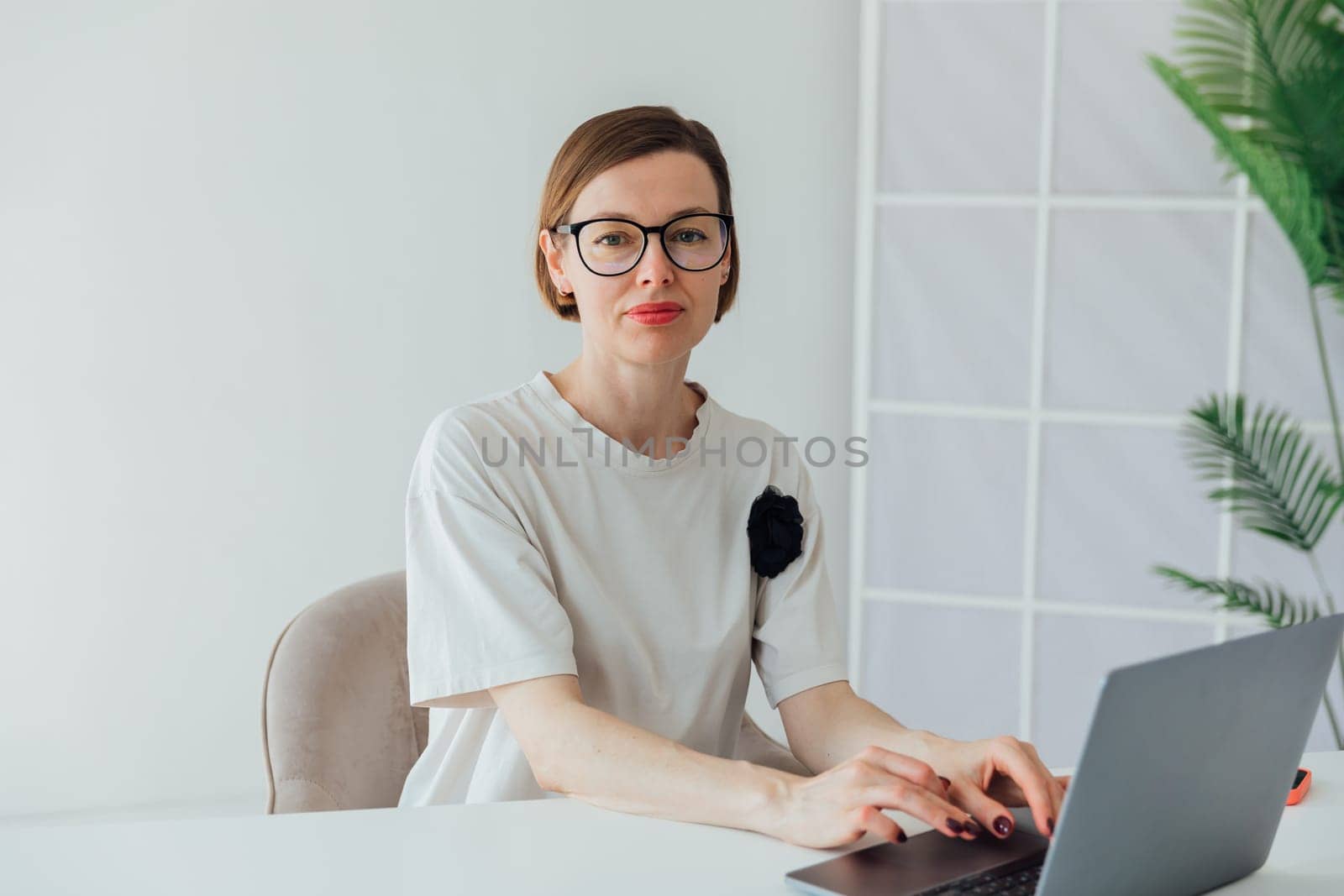 Business woman in glasses working on laptop in office