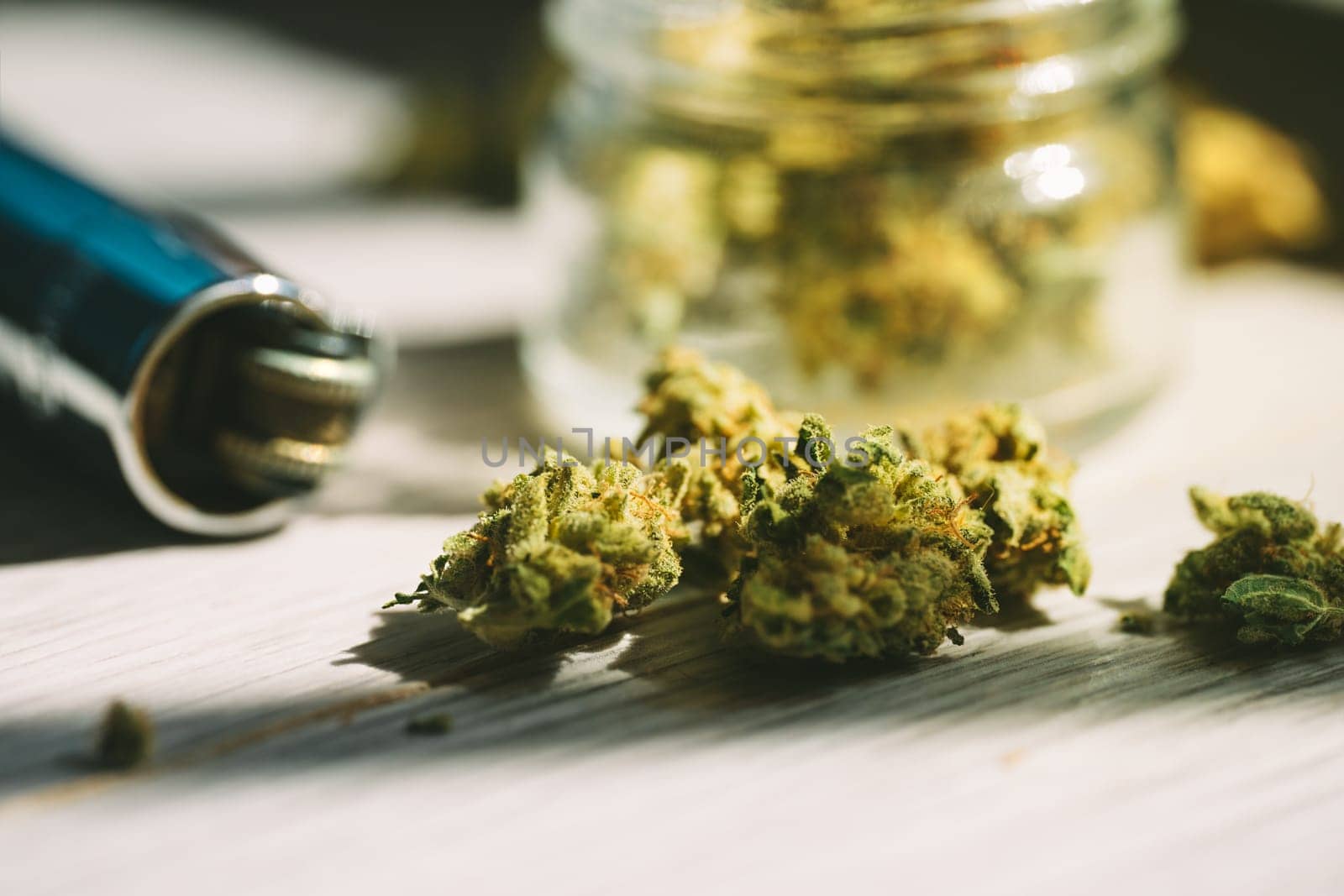 Close up of medical marijuana or cannabis flower buds and lighter. by DariaKulkova