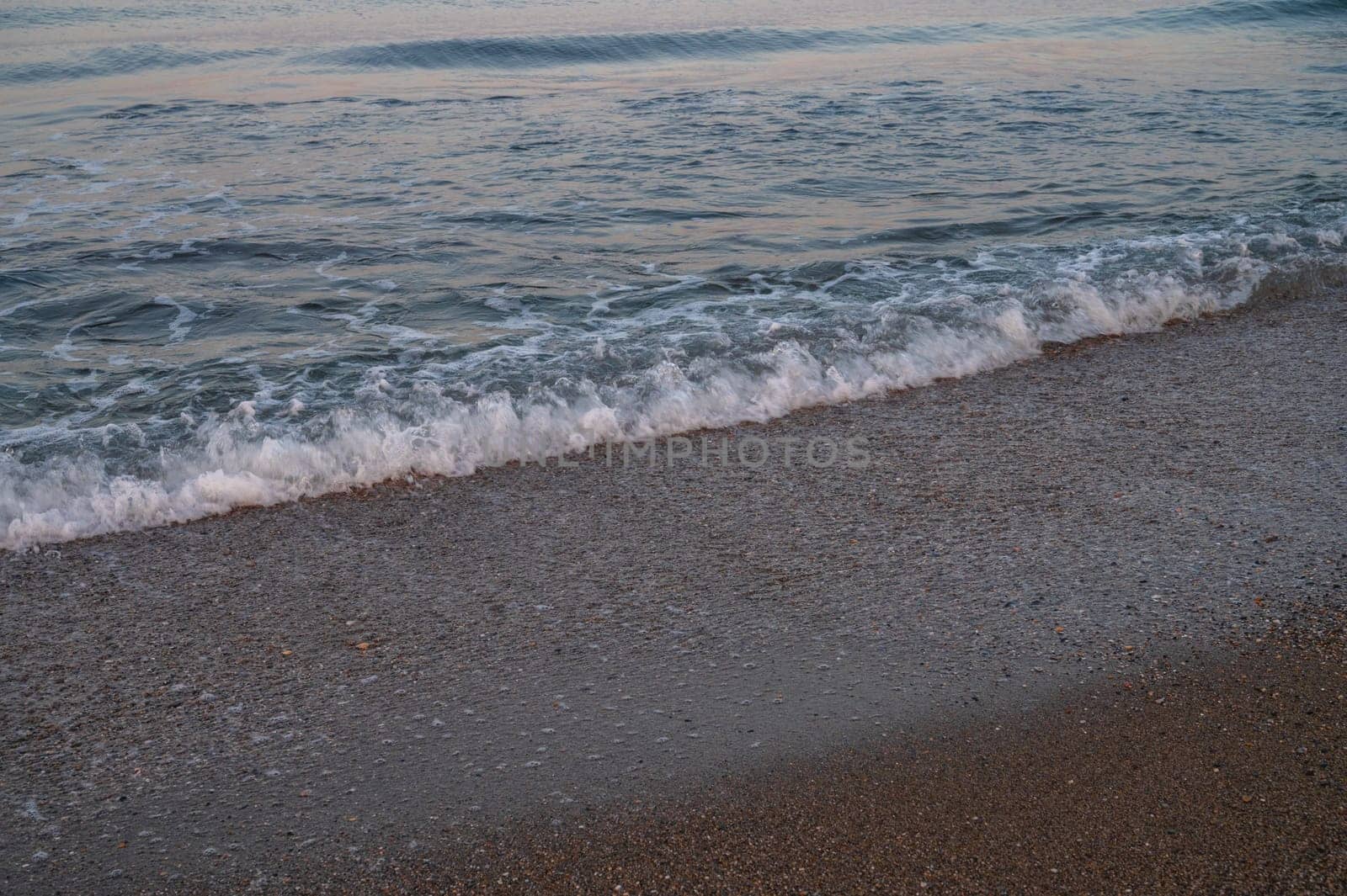 Waves of Mediterranean Sea rolling to the sandy Turkish beach. Beautiful Turkish evening.