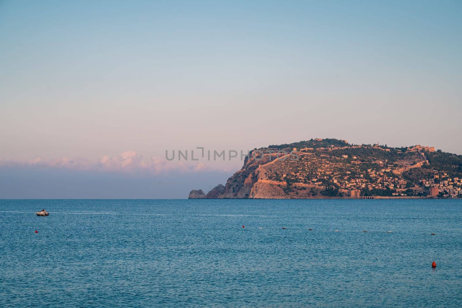 Beautiful sunrise scene on Alanya beach with view to famous Alanya island, in Turkey