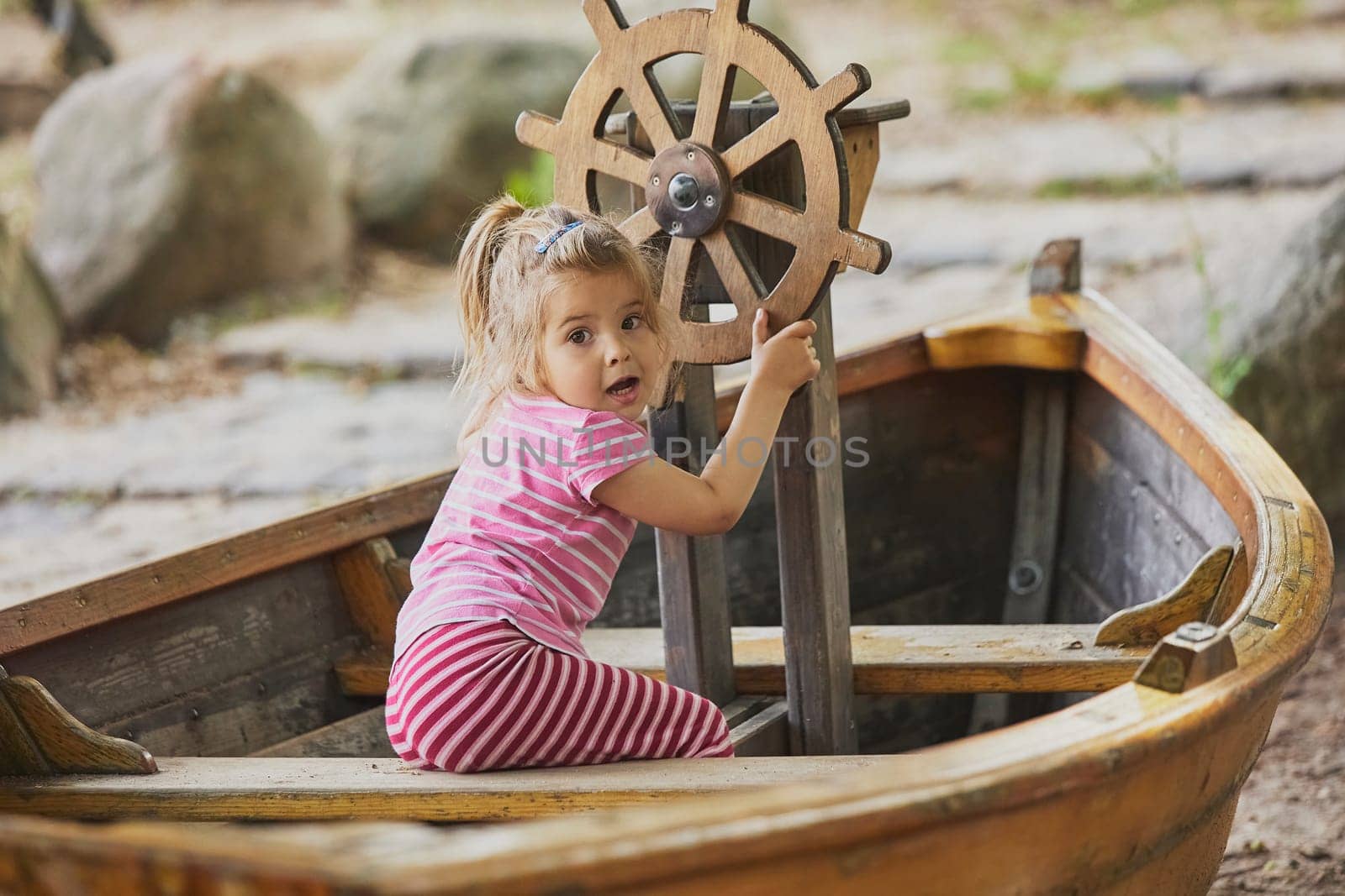 Charming child playing in a toy boat in Denmark.