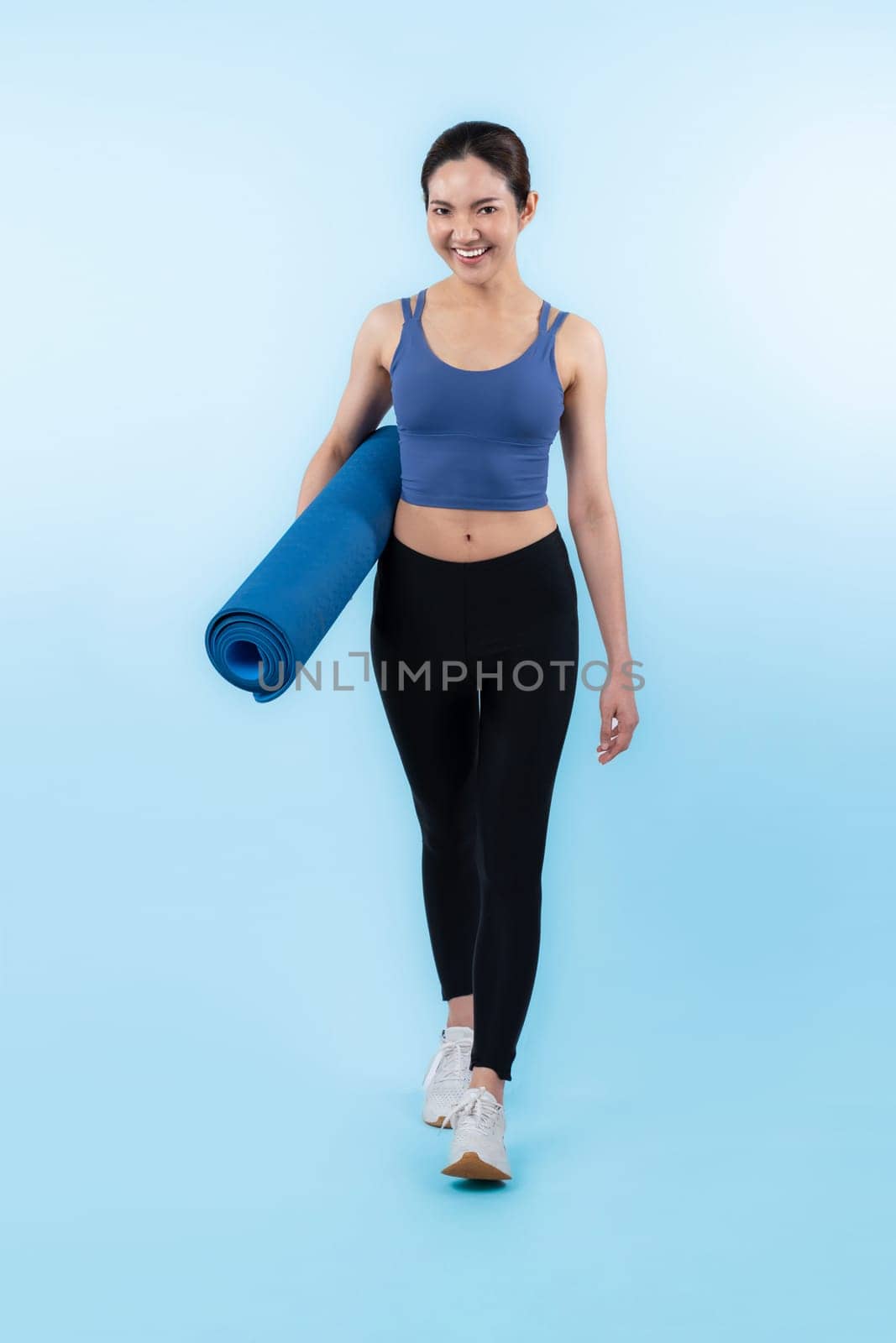 Young attractive asian woman portrait in sportswear with exercising mat. Healthy exercise and workout routine lifestyle concept. Studio shot isolated background. Vigorous