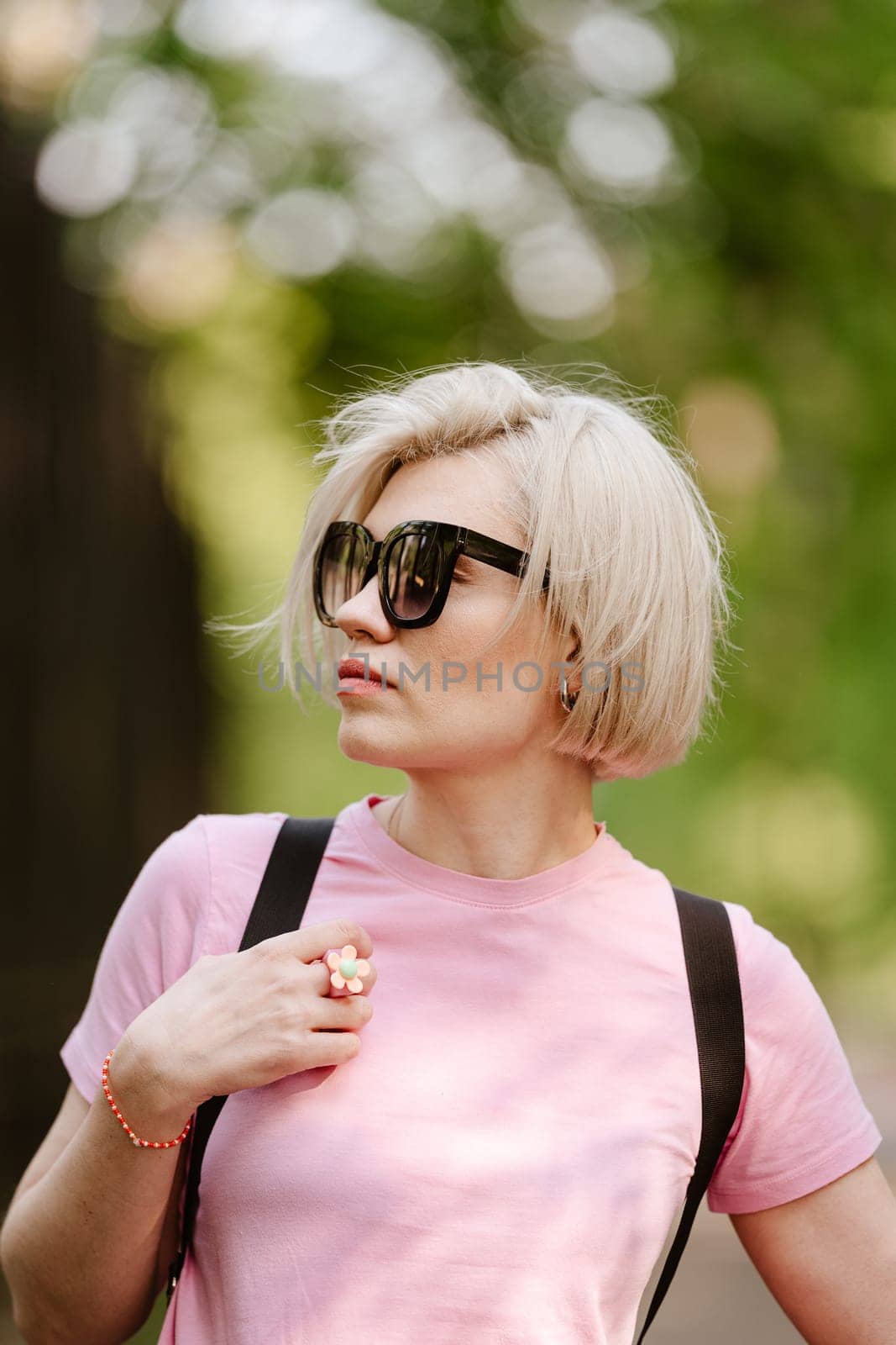 Beautiful fashionable young woman posing in the park by sarymsakov