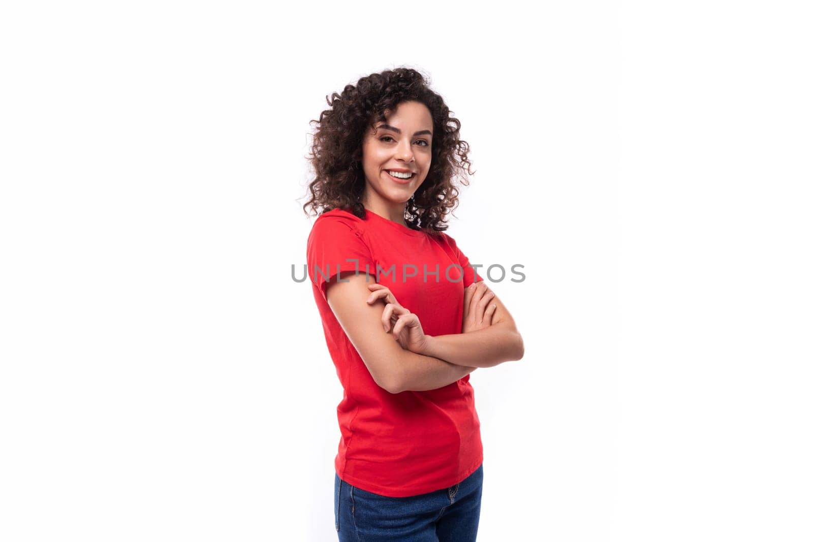 corporate clothing concept. young smiling curly brunette woman in red t-shirt on white background with copy space.