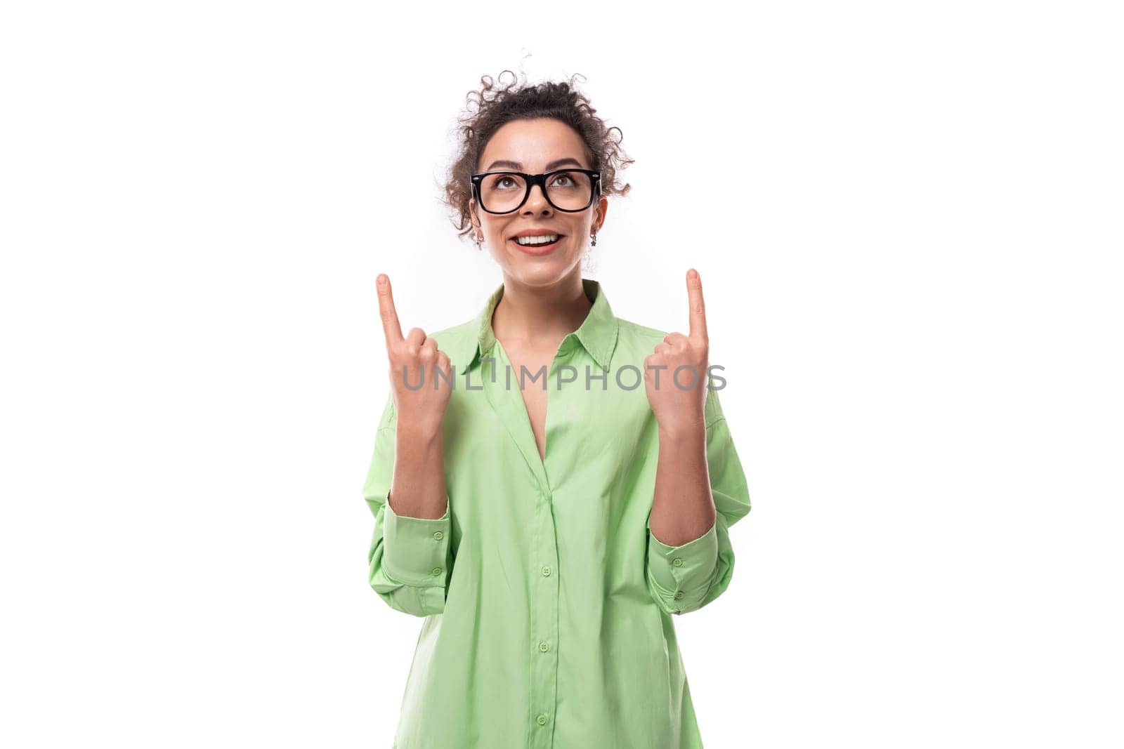 young smart inspired european brunette curly woman dressed in light green shirt and glasses.