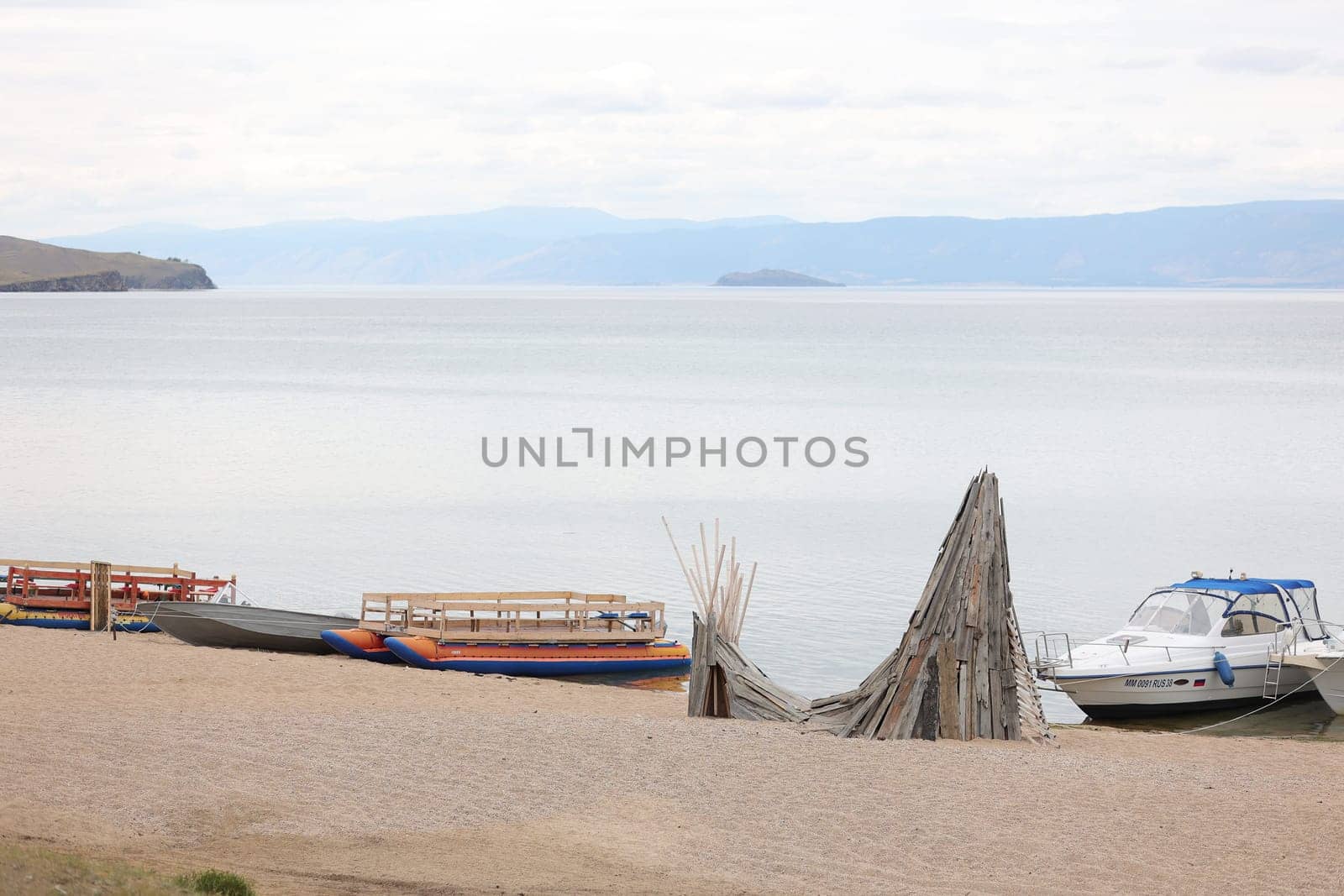 Baikal pier for boats and catamarans on Olkhon Island against the background of mountains and Lake Baikal