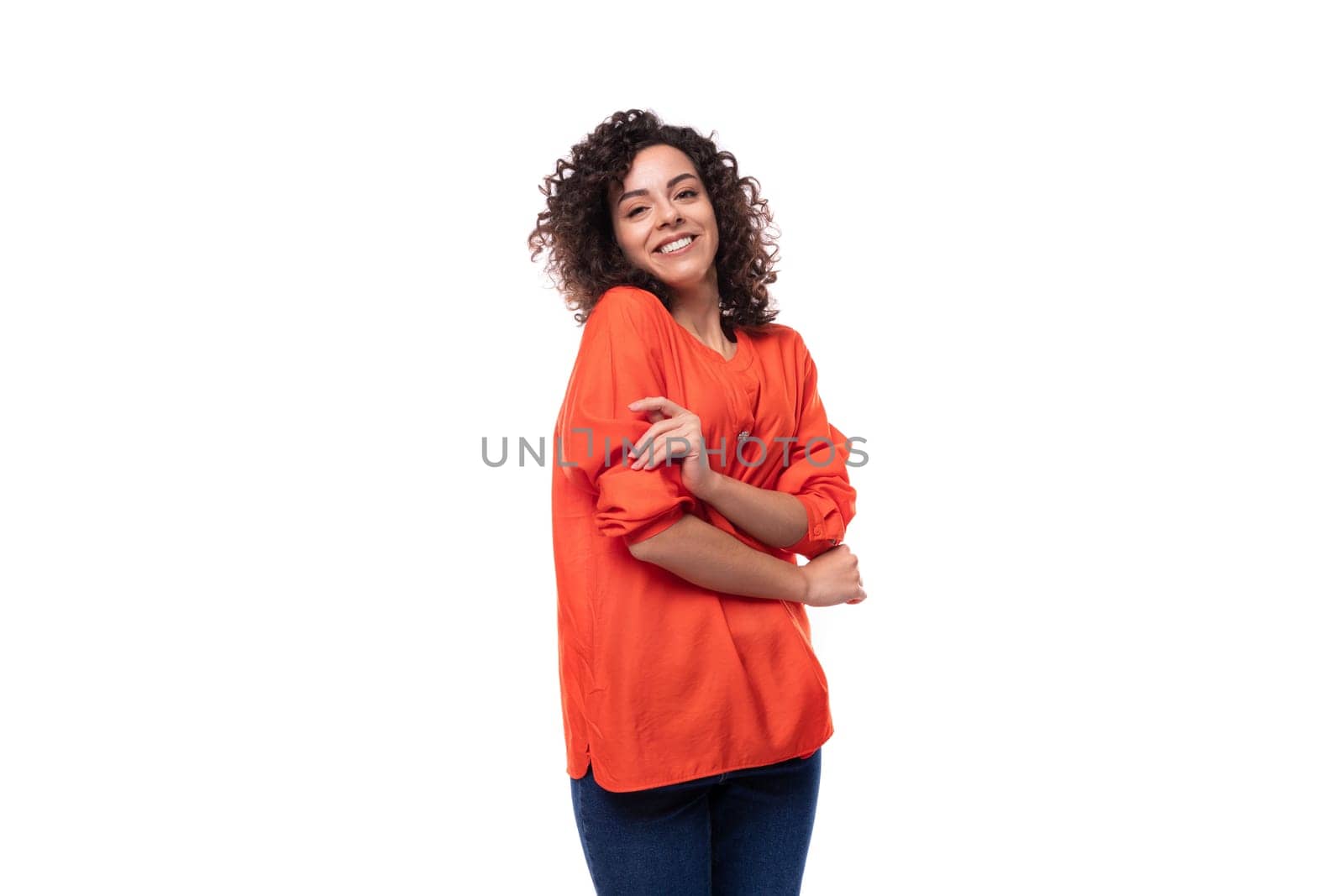 young cheerful caucasian lady with curly hair style dressed in orange shirt.