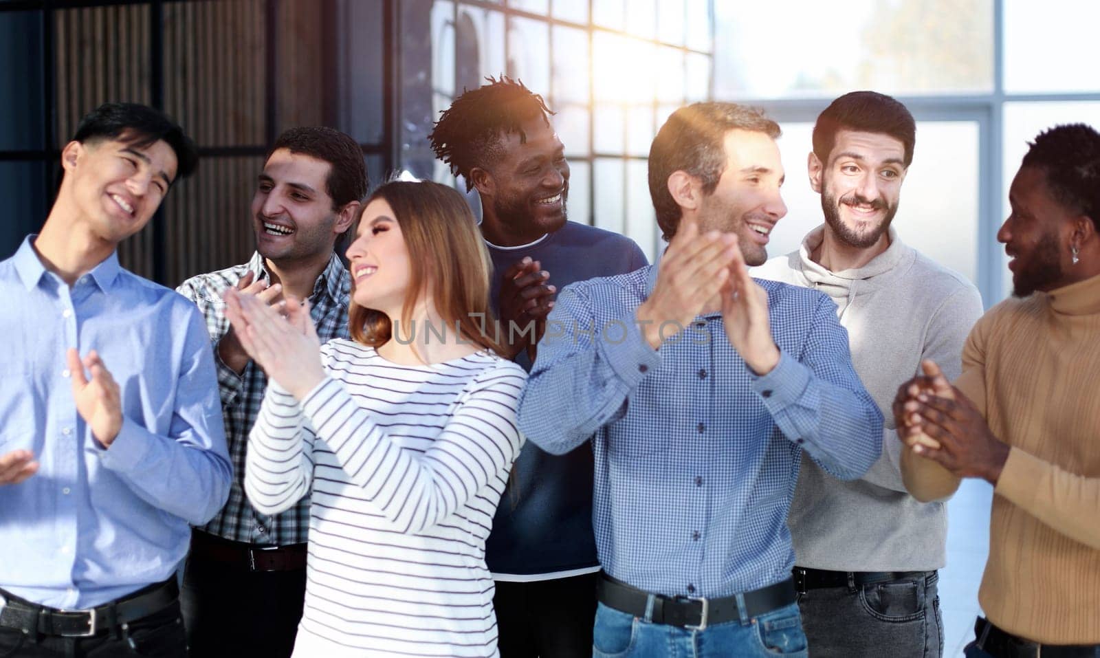 Happy satisfied multi-racial business people dressed in casual clothes cheering at camera after attending corporate seminar in office