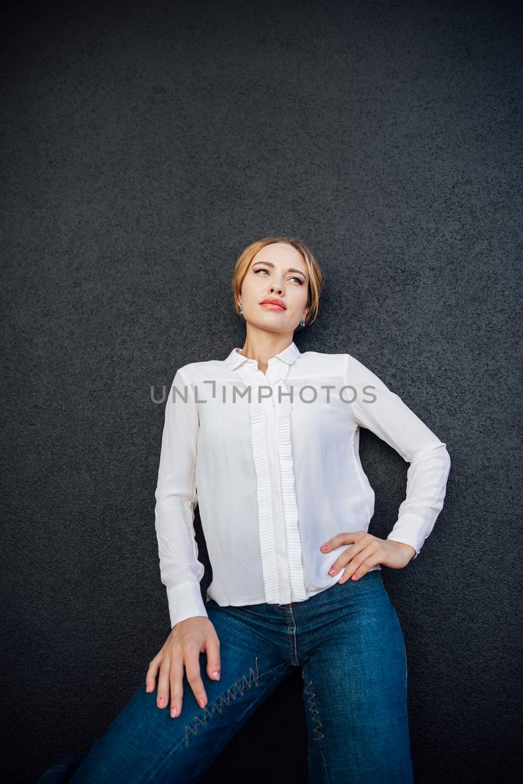 Portrait of a slender fashionable young woman outdoors by Simakov