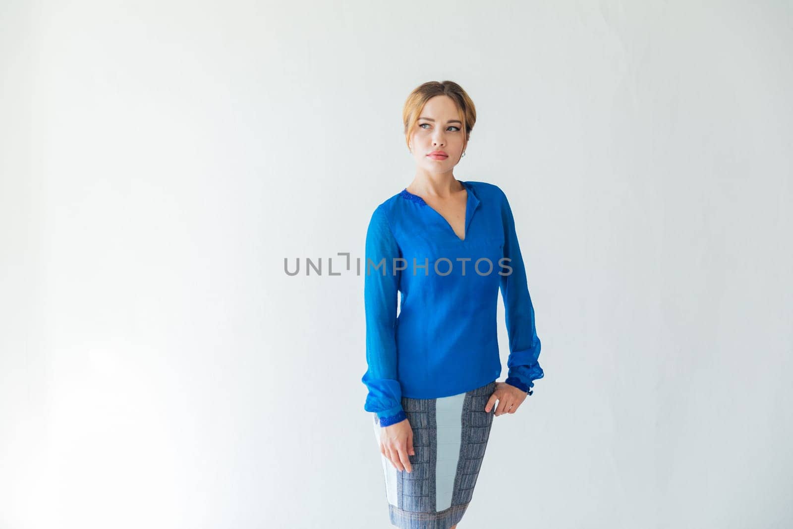 Beautiful fashionable young woman in blue on autumn city street