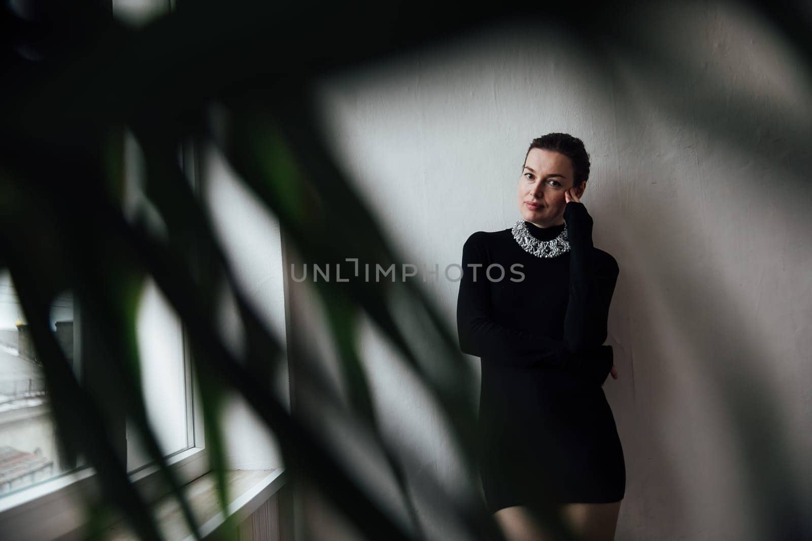 Portrait of beautiful fashionable woman with short haircut in black evening dress