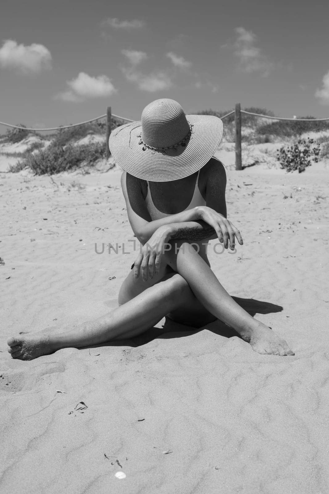 girl takes a photo on the beach in a hat, there is a place for an inscription, the photo is black and white. High quality photo