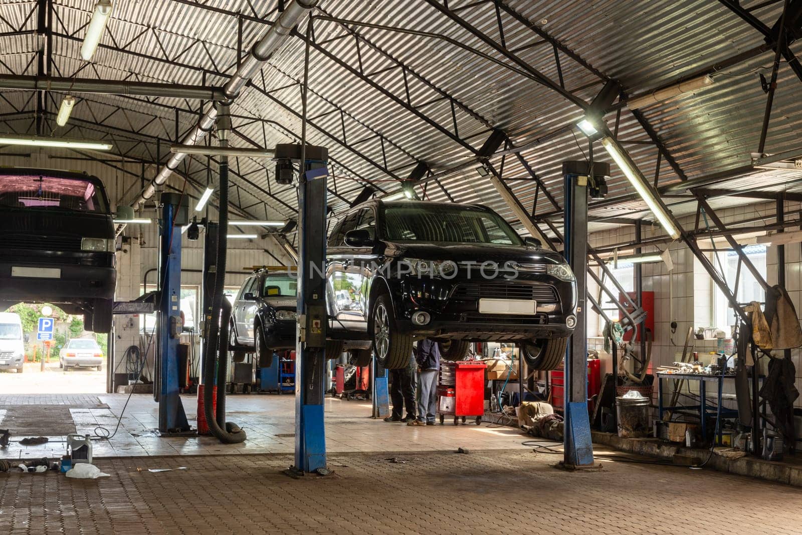 Cars in automobile repair service center. Modern car repair station with a large number of lifts and specialized equipment for diagnostics and service repair car