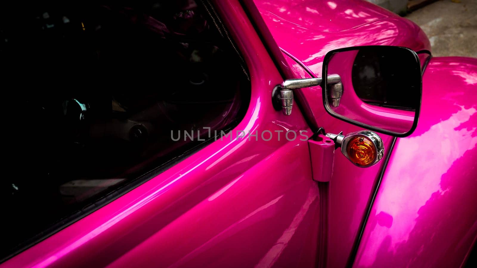 Side mirror and window of pink vintage retro vehicle car