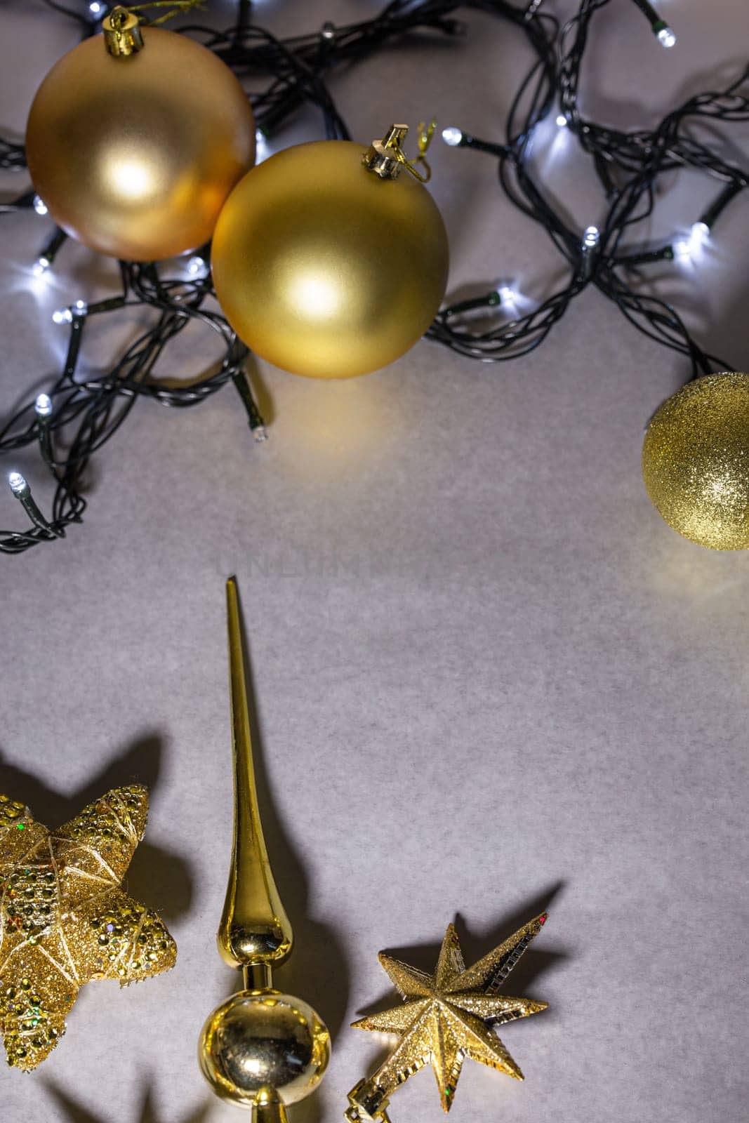 top view New Year's gray background with golden toys and garlands.