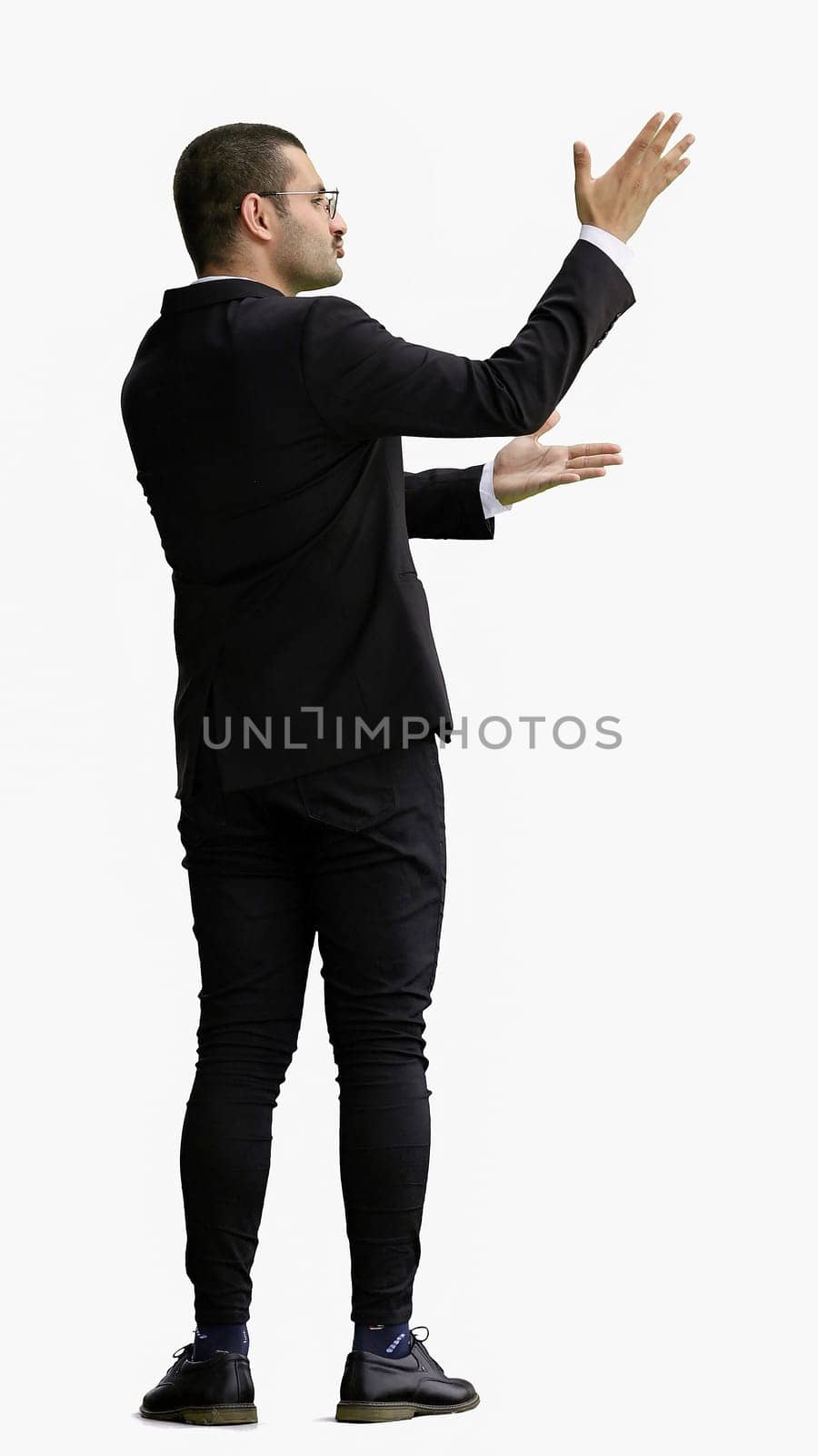 young man in full growth. isolated on a white background shows hands to the side by Prosto