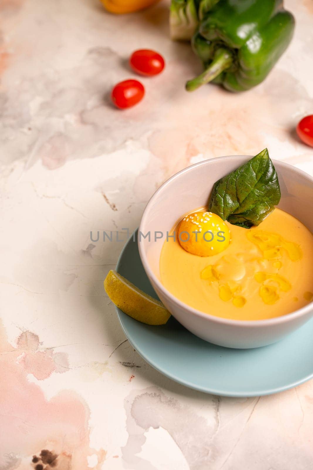 pumpkin cream soup with a slice of lemon in a plate on the table by Pukhovskiy