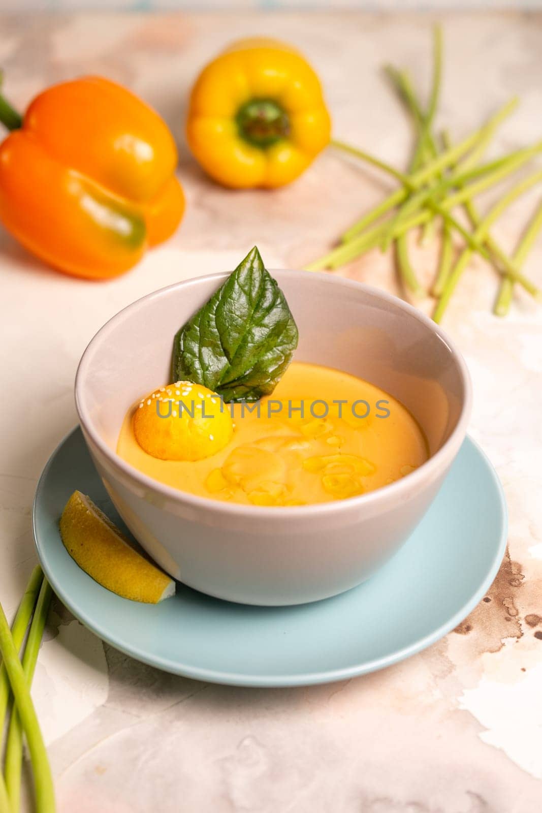 pumpkin cream soup with a slice of lemon in a plate on the table by Pukhovskiy