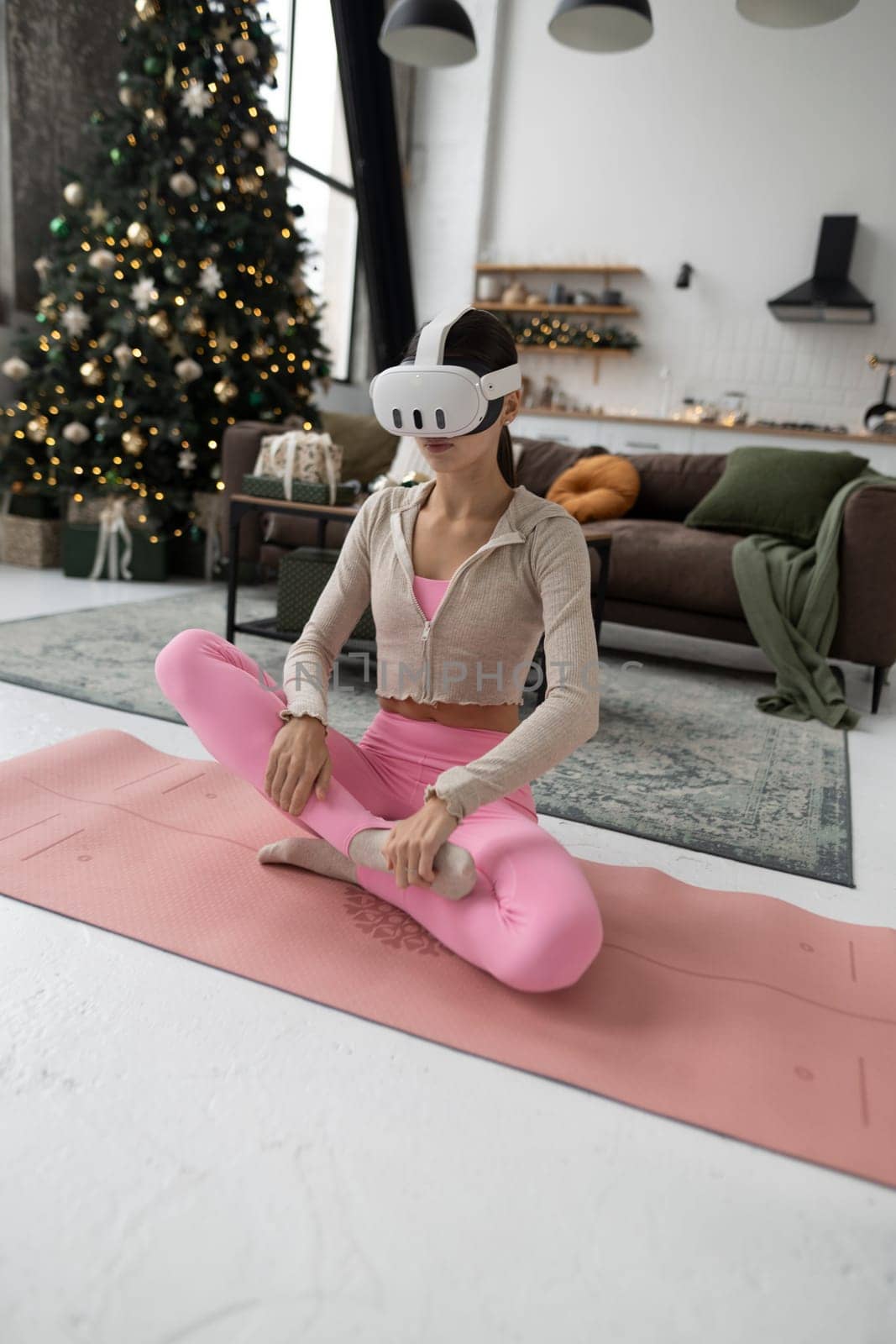 In pink workout attire, a woman engages in yoga while wearing VR goggles. by teksomolika