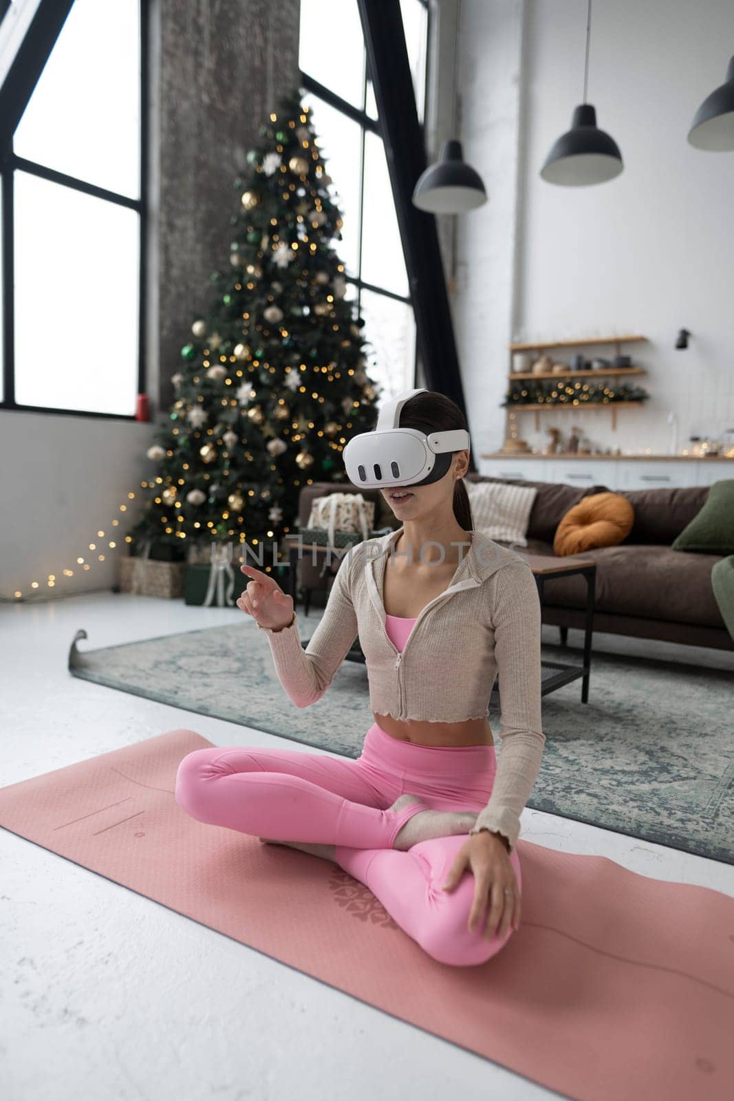 A chic young woman celebrates the Christmas holidays with a virtual reality headset. High quality photo