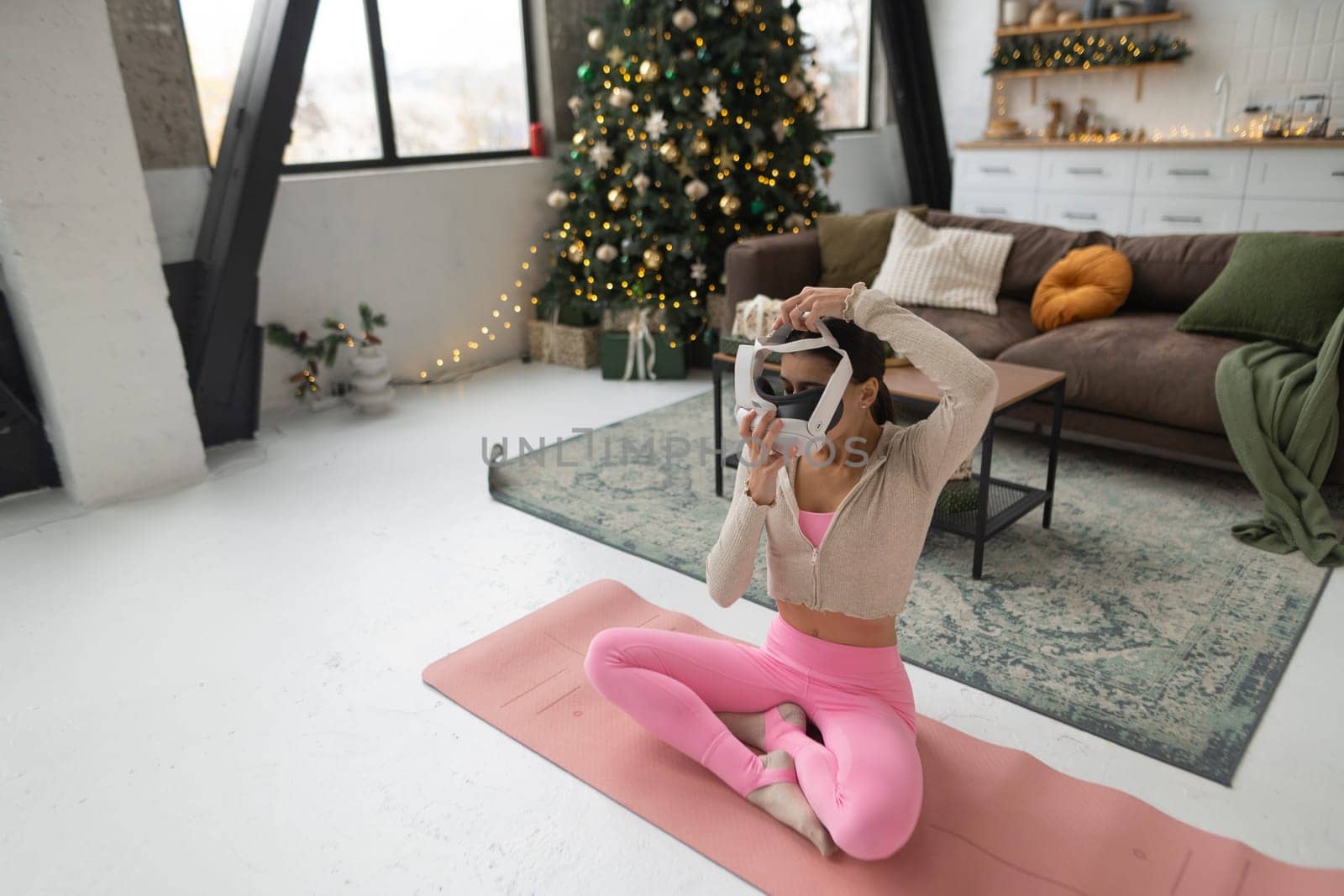 Donning pink athletic attire, the woman practices yoga in virtual reality. High quality photo