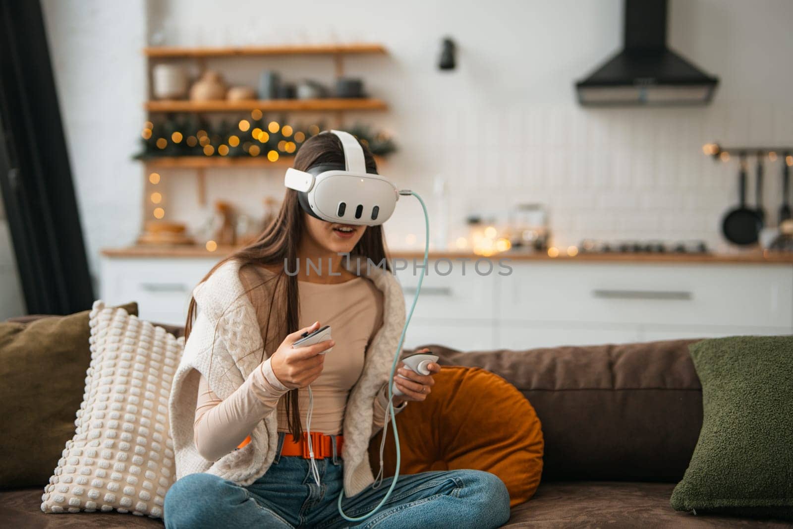 A stylish young woman in a cozy Christmas atmosphere at home, wearing a virtual reality headset. by teksomolika