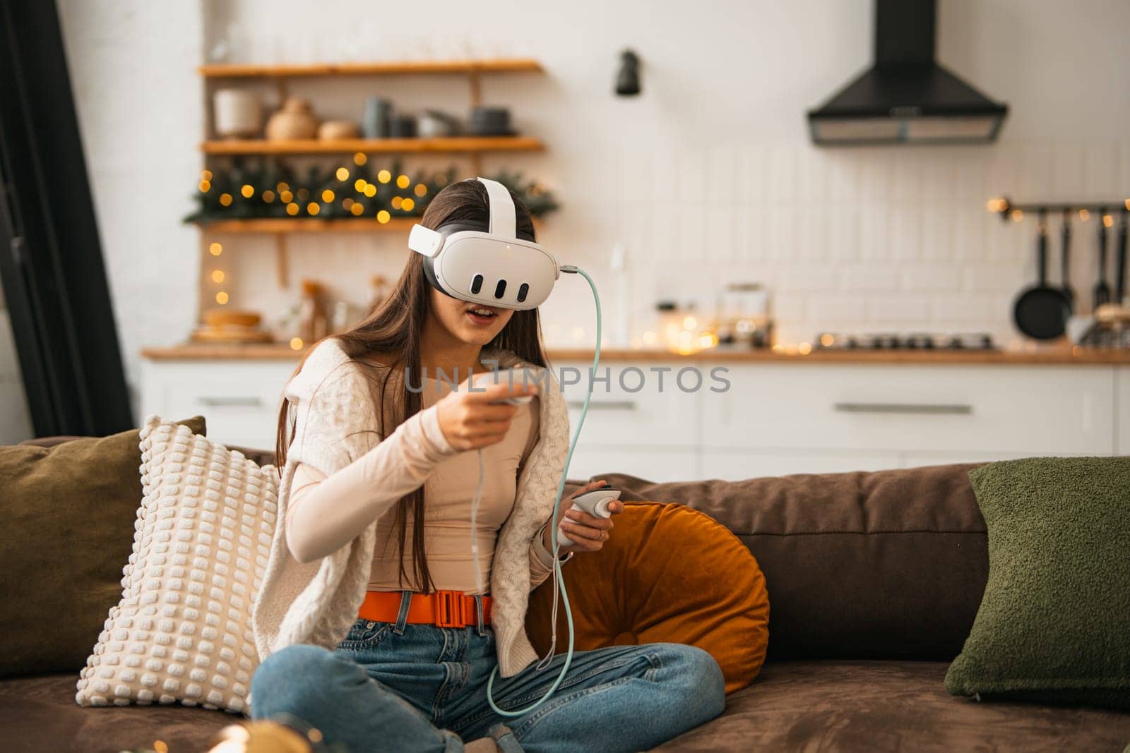 Amidst a cozy Christmas scene at home, a trendy young lady enjoys a virtual reality headset. by teksomolika