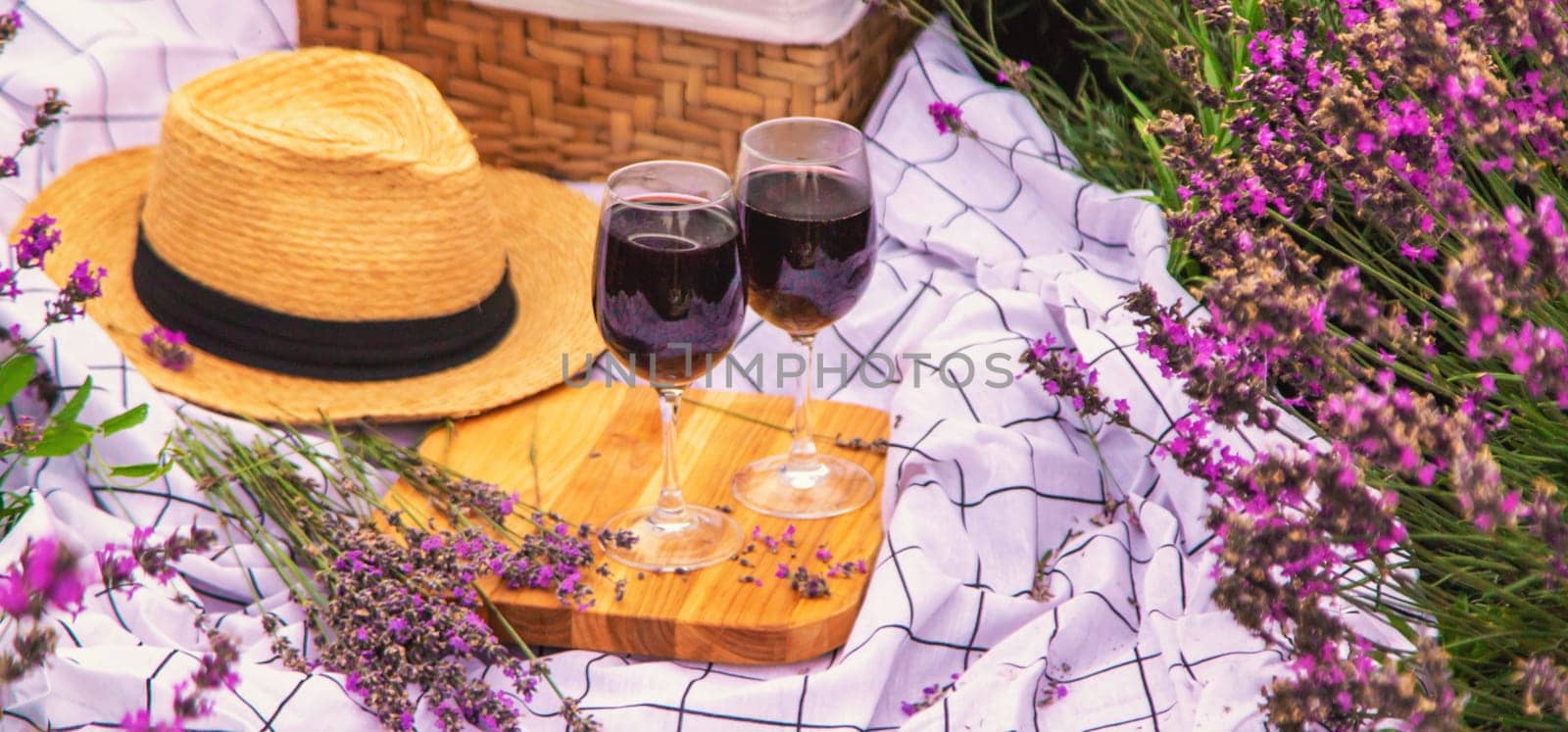 A woman drinks wine in a lavender field. Selective focus. by yanadjana